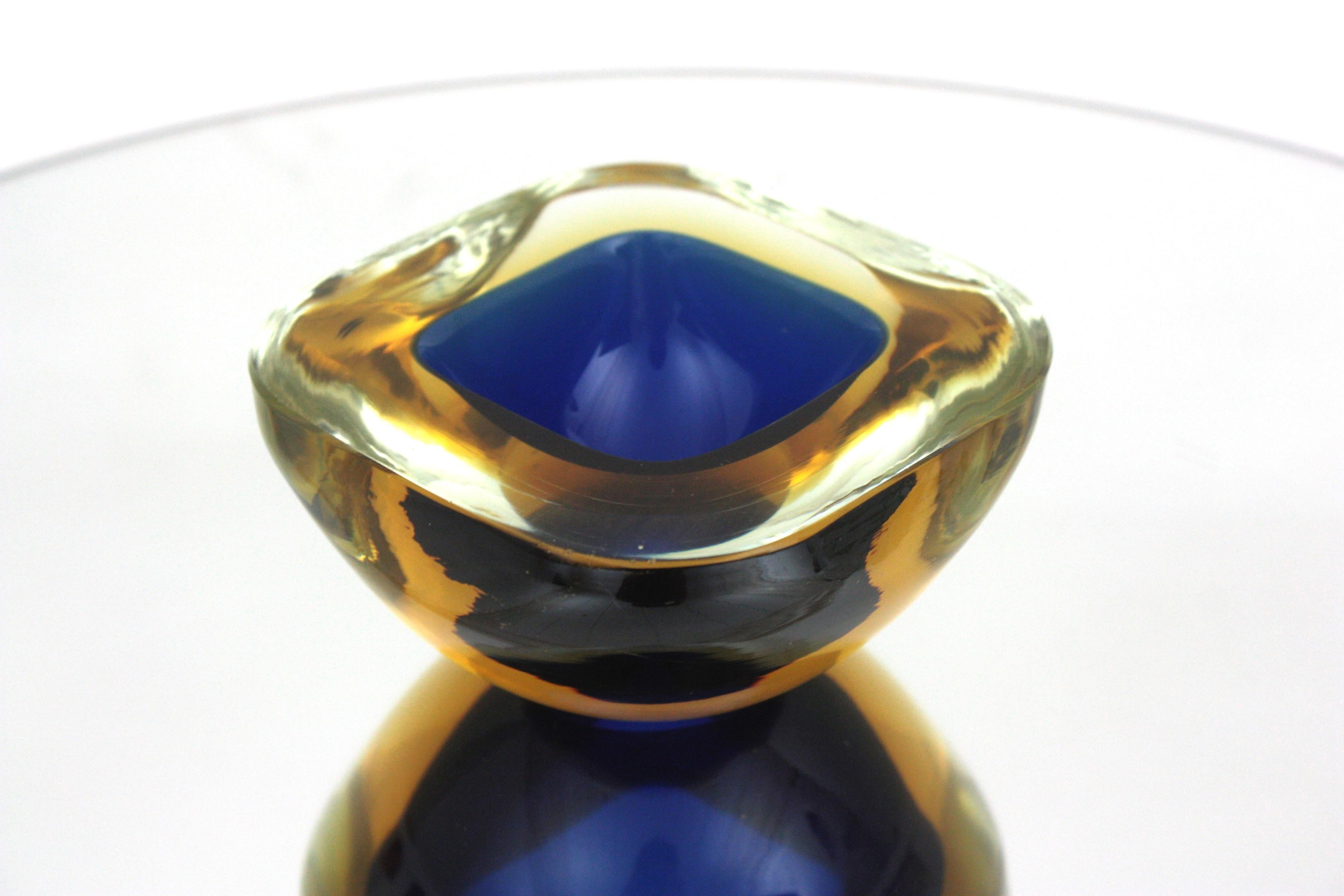 Italian Murano art glass square shaped geode bowl attributed to Flavio Poli for Seguso Vetri d'Arte. Italy, 1950s.
Beautiful hand blown Murano glass piece combining amber yellow, blue and clear glass with Sommerso technique. 
This decorative bowl