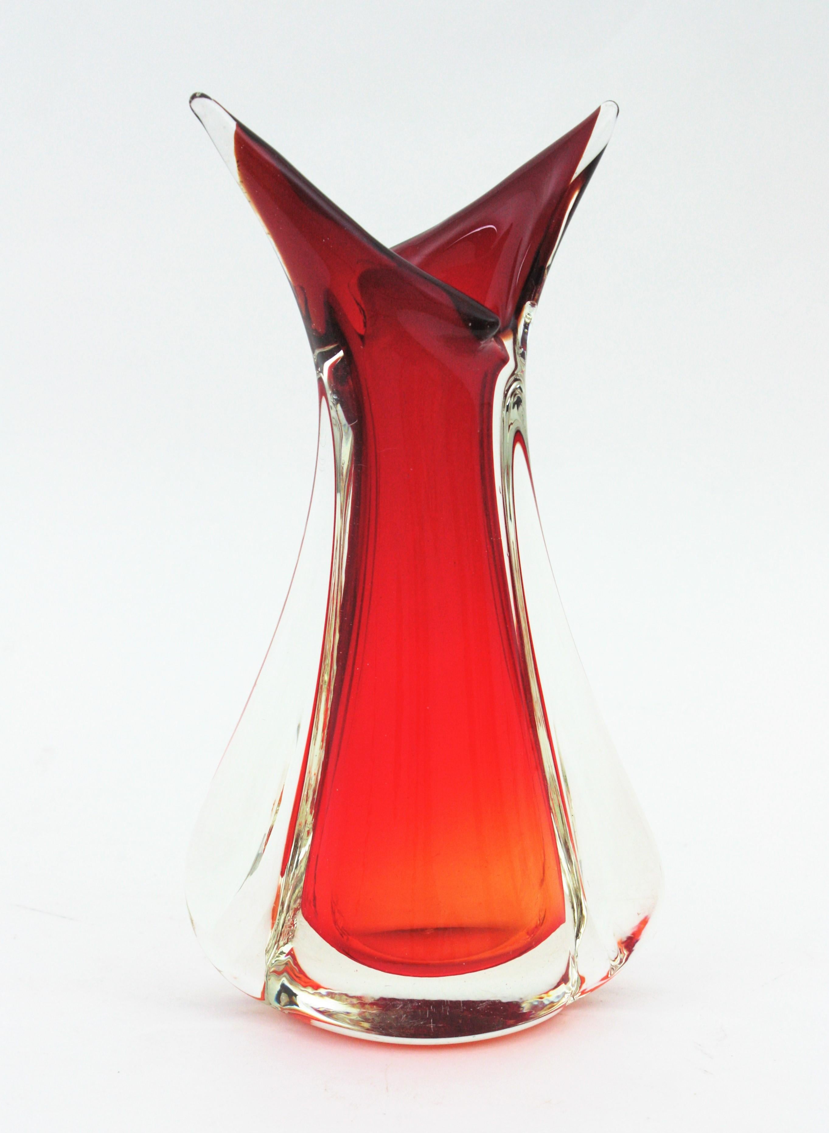 Skulpturale Vase aus Murano-Kunstglas in Rot- und Orange-Tönen. Entworfen von Flavio Poli und hergestellt von Seguso Vetri d'Arte. Italien, 1950er Jahre.
Lebendige Farben: Rotes und orangefarbenes Glas, das mit der Sommerso-Technik in klares Glas