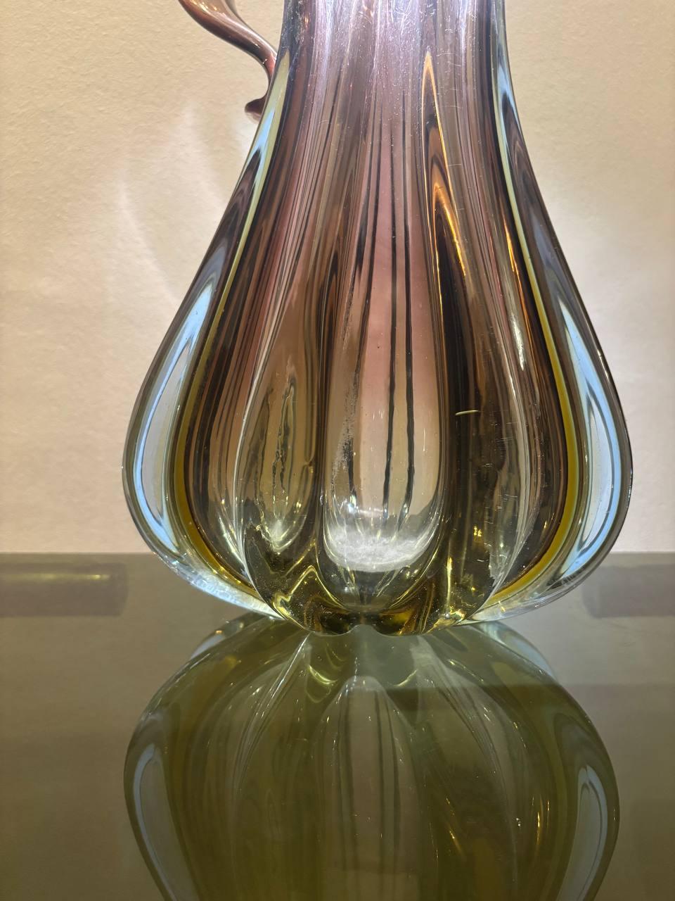 Sculptural Murano Jug Shaped Vase in Shades of Pink and Amber glass. Designed by Flavio Poli and manufactured by Seguso Vetri d'Arte. Italy, 1950's.
Large size.
Vibrant colors in a gradient of hues ranging from the  purple to amaranth to amber