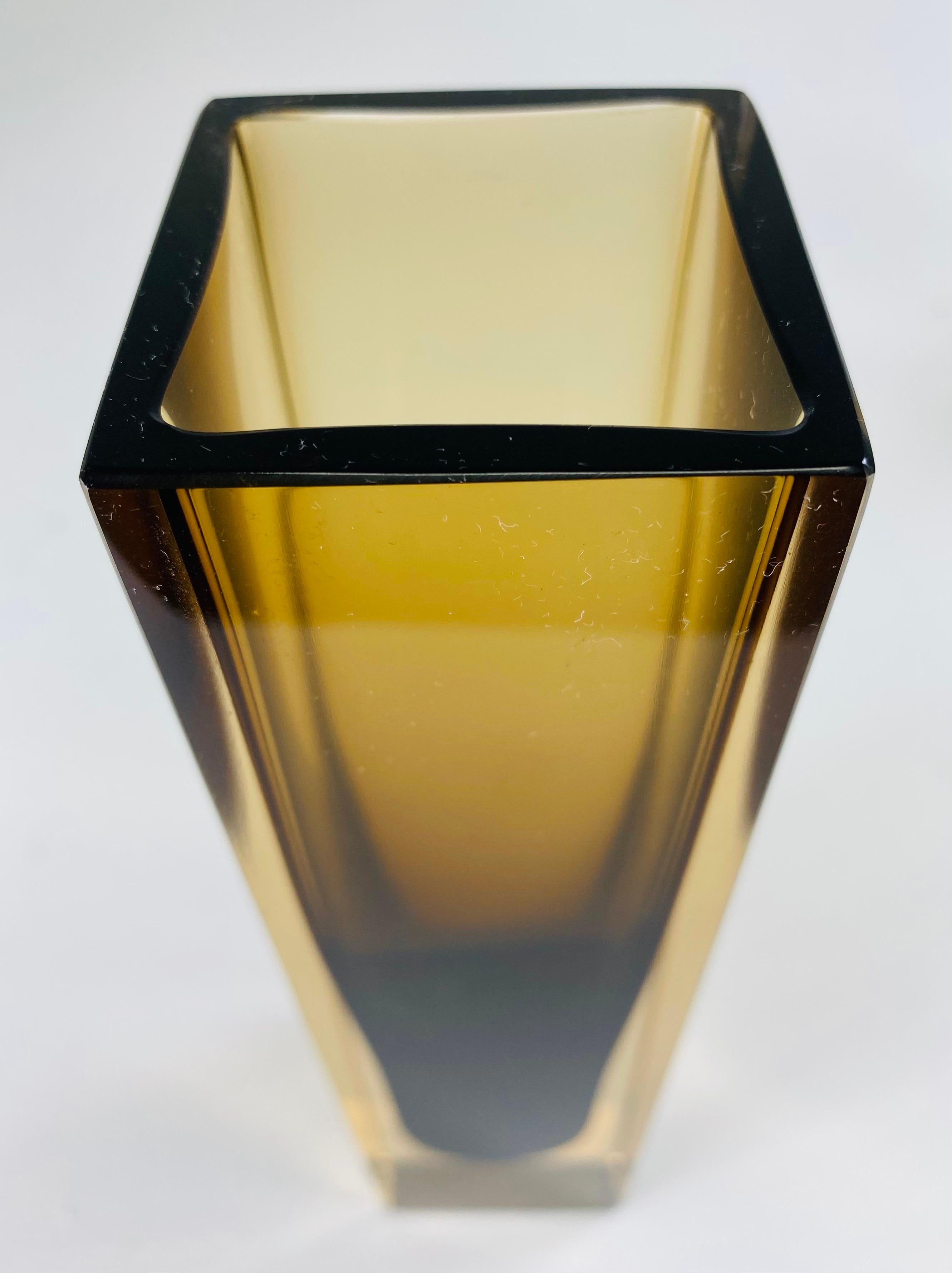 This is a mid-century modern handblown art glass vase from Murano Italy. This vase has a dark brown interior incased in a soft amber clear glass exterior. This solid modern vase was made by Flavio Poli in Murano Italy circa 1970.