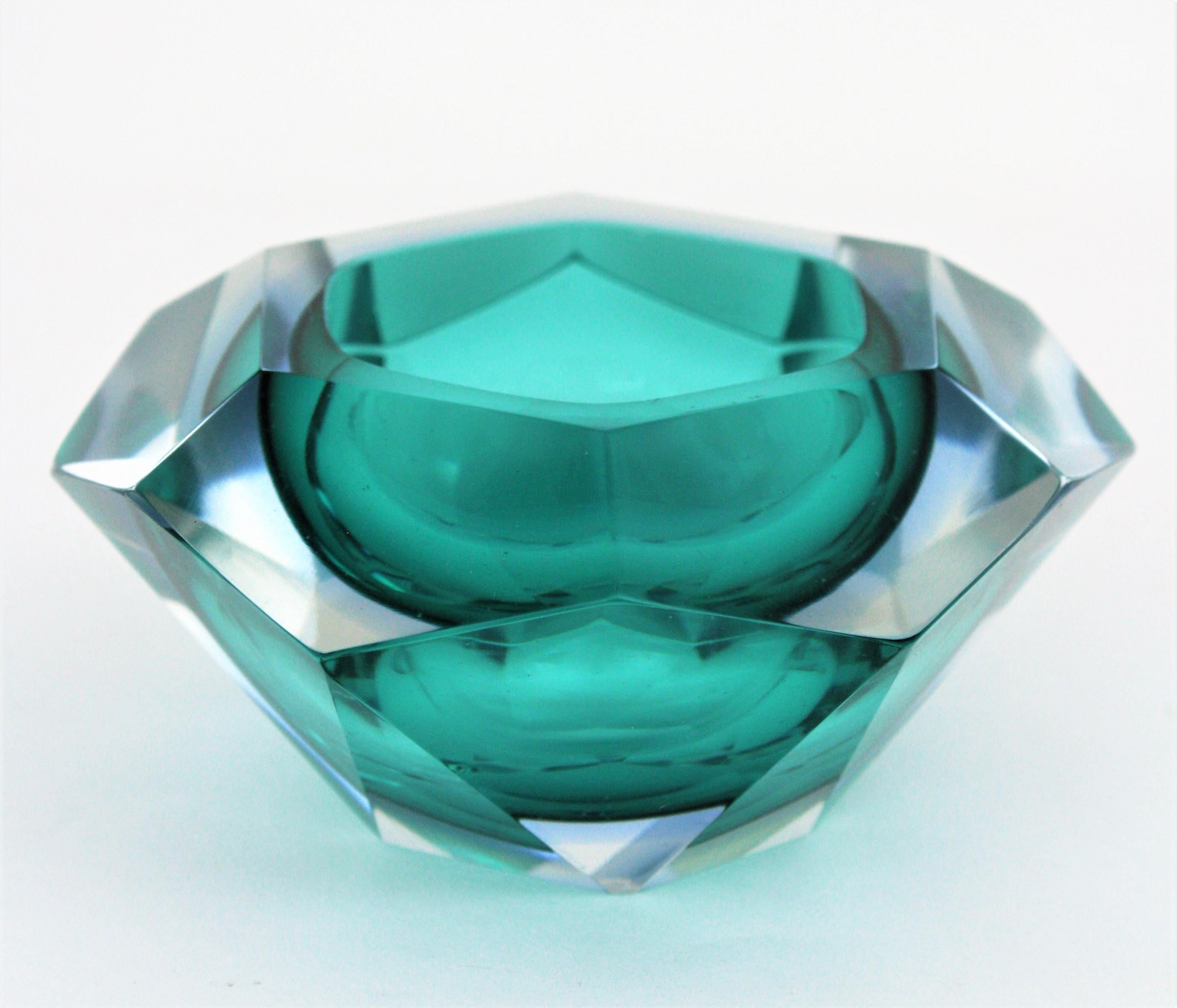 Amazing petroleum green Murano glass faceted bowl or ashtray by Flavio Poli. Italy, 1950s.
Unusual color. Petroleum green and a line in blue glass cased into clear glass with the Sommerso technique.
Amazing diamond shape and funny color. It has 19