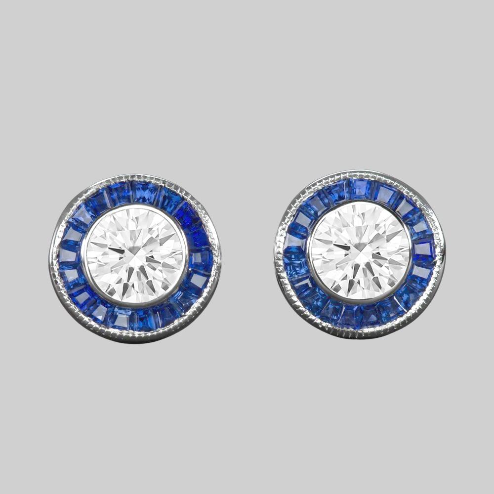 Elegant and brilliantly sparkling blue sapphire diamond earrings bring the glamour with a chic and sophisticated Art Deco style design! 

The setting features rich blue sapphire meticulously calibre cut to fit the iconically Art Deco channel halo