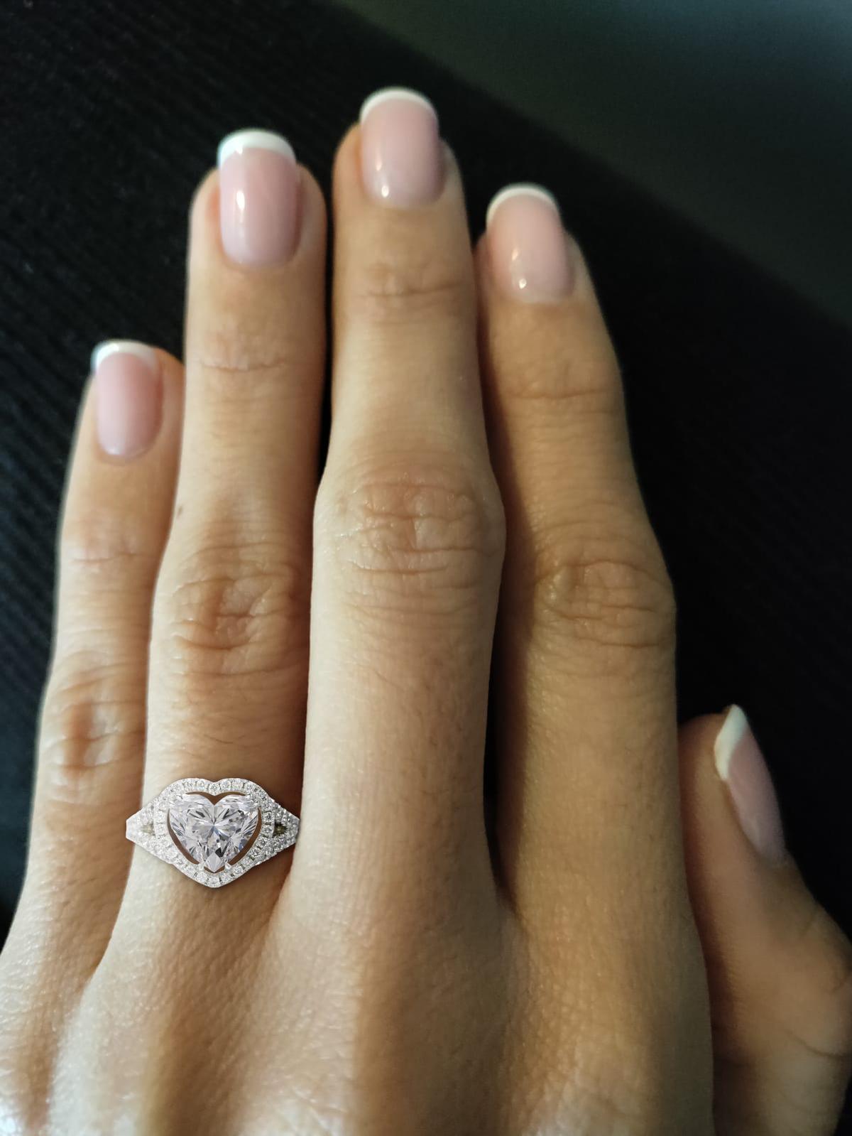 This exquisite GIA-certified ring features a stunning 2.03-carat heart-cut diamond at its center, embodying romance and elegance.

Set in luxurious platinum, the ring's design showcases a captivating halo of small round diamonds that enhance the