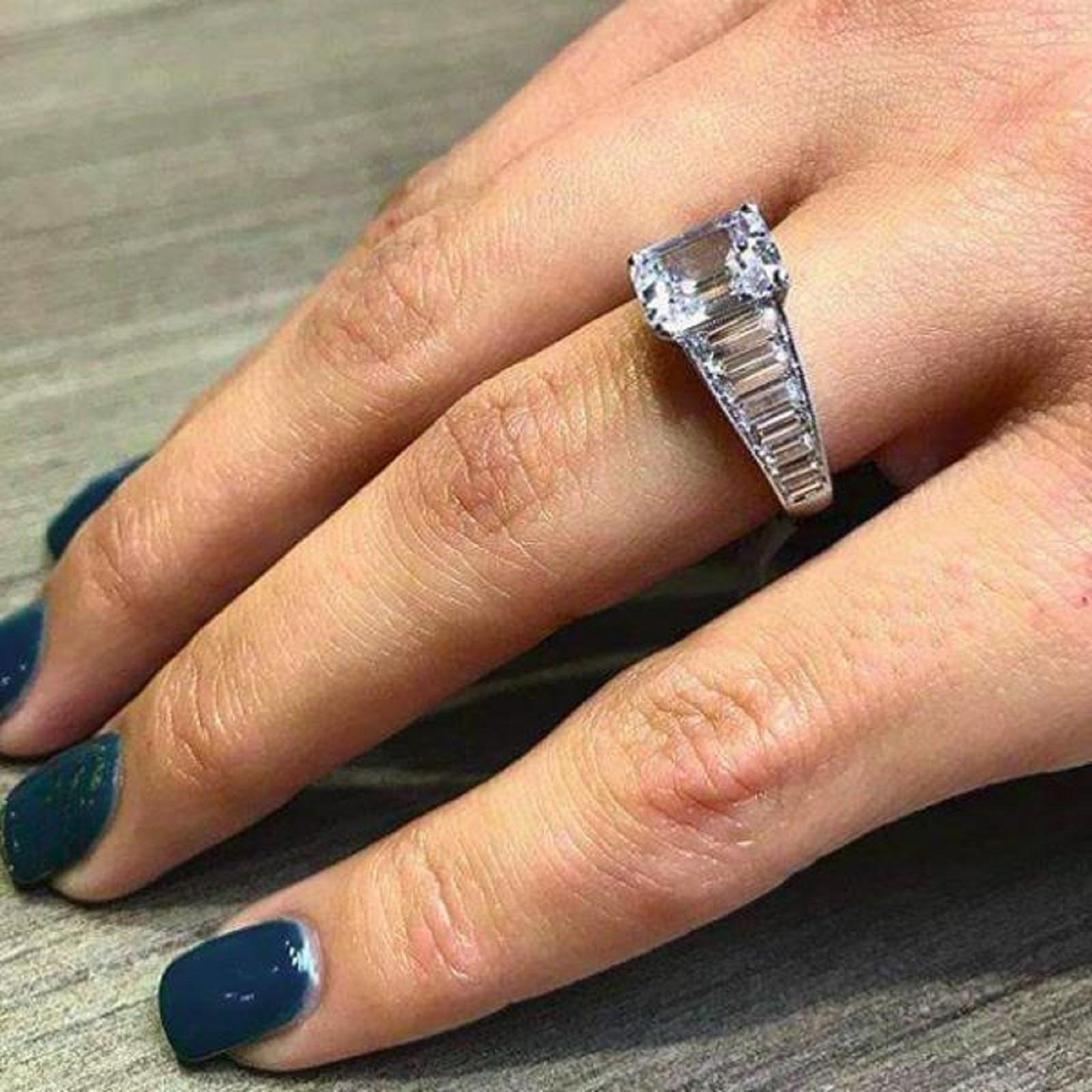 An exquisite emerald cut diamond ring with a beautiful handmade in Italy solid platinum mounting that is composed by emerald cut diamonds at each side all very clear and full of brilliance.

The main stone is totally white faced consider GIA has