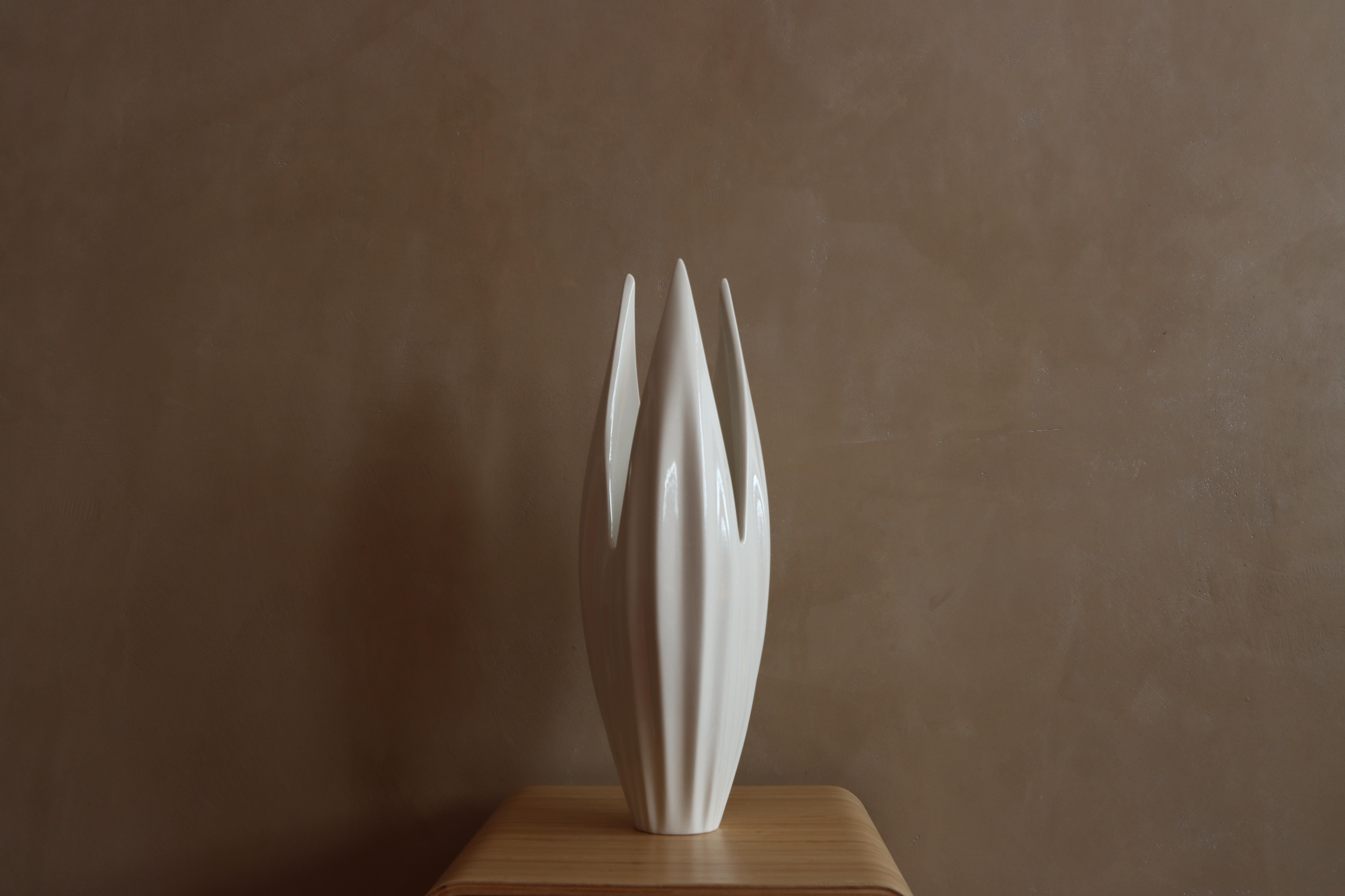 Introducing the Flax Vessel, a stunning, hand-crafted porcelain sculpture that adds a touch of elegance to any home or office space. This versatile piece can be used in a myriad of ways, whether to display your favourite flowers, hold a pillar