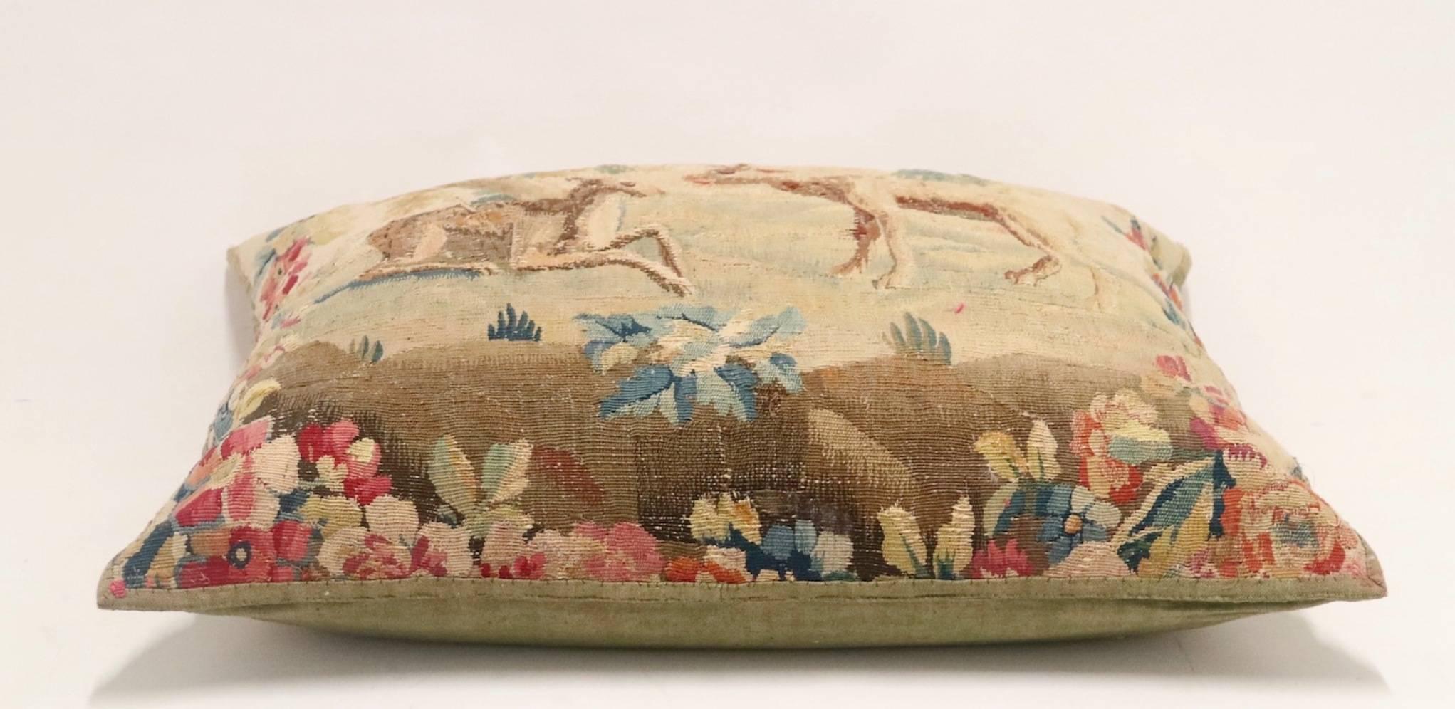 Flemish 17th century tapestry made into a pillow consisting of cotton and silk. The tapestry depicts two deer in a field with flowers and is completely handmade with the original linen intact on the pillow's verso. This item is in excellent antique