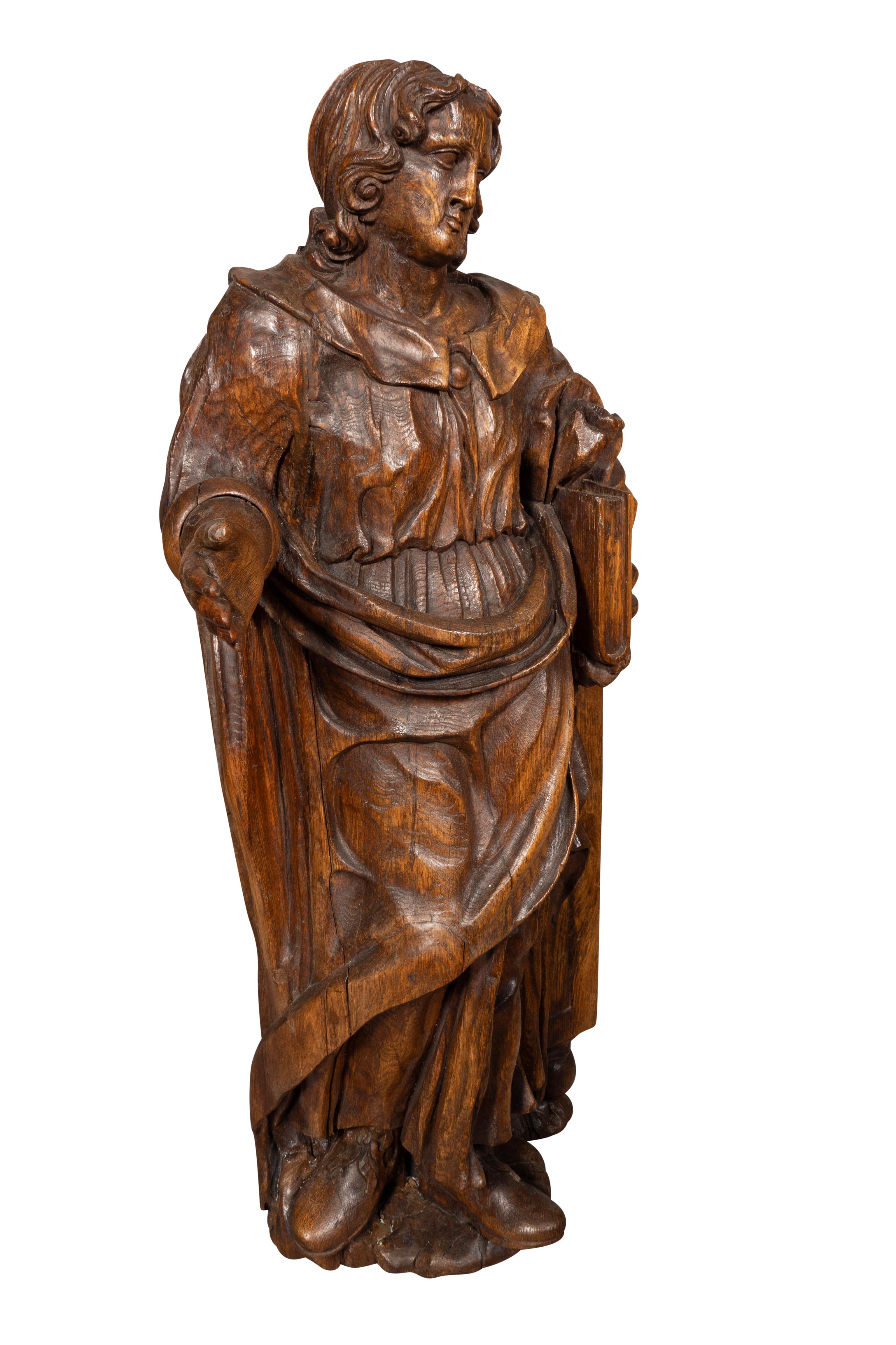 Grande figura in piedi con un libro sotto il braccio e la mano tesa. 