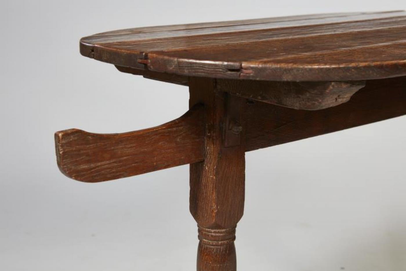 Good 17th century Flemish oak oval hunt or tavern table having unusual hook ends over turned legs joined by shoe feet, the whole possessing mellow silvery brown patina.

Width listed below is overall (including hangers) actual length of top 33