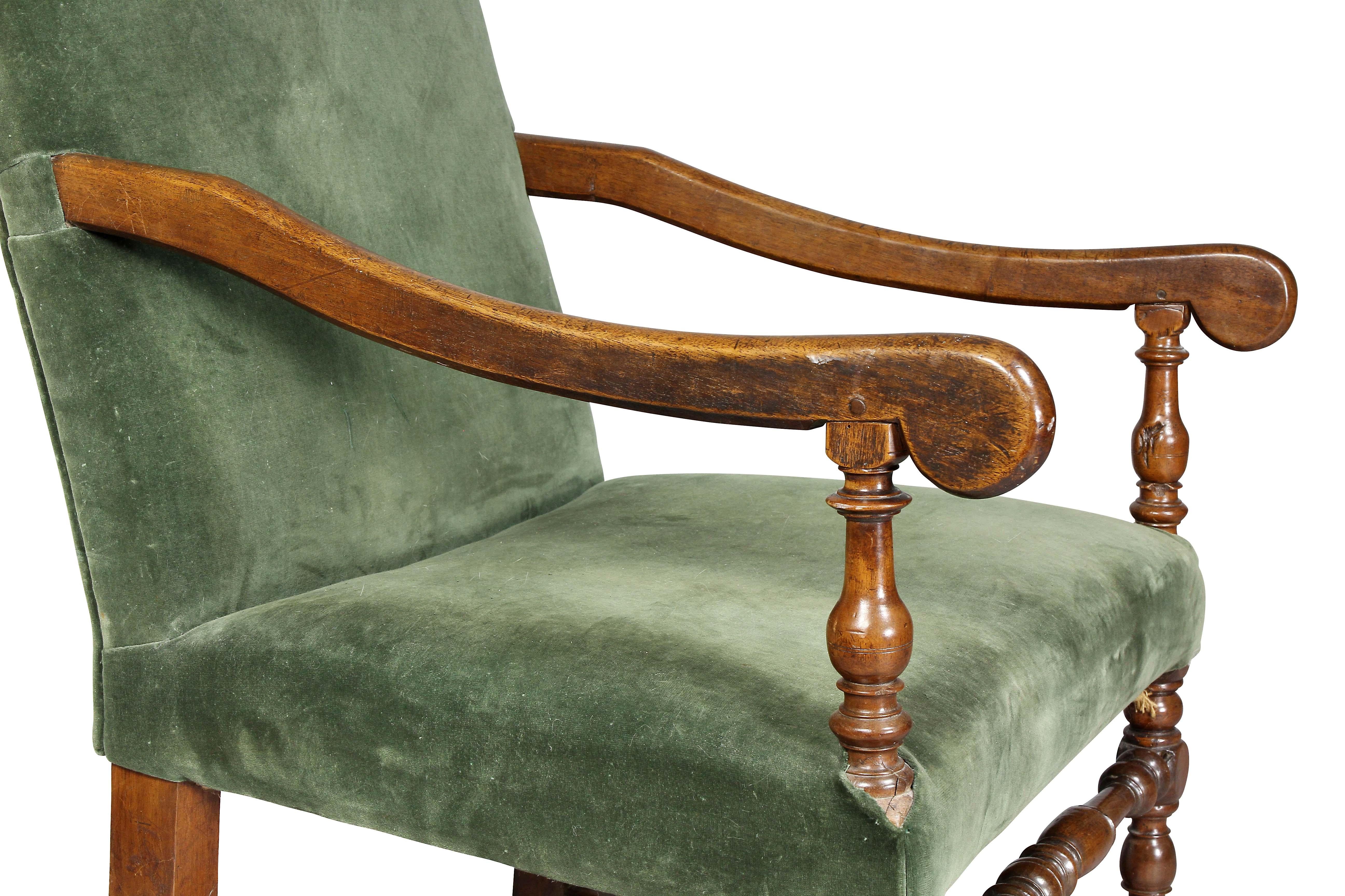 Arched upholstered back, downswept arms, turned legs and H-stretcher.