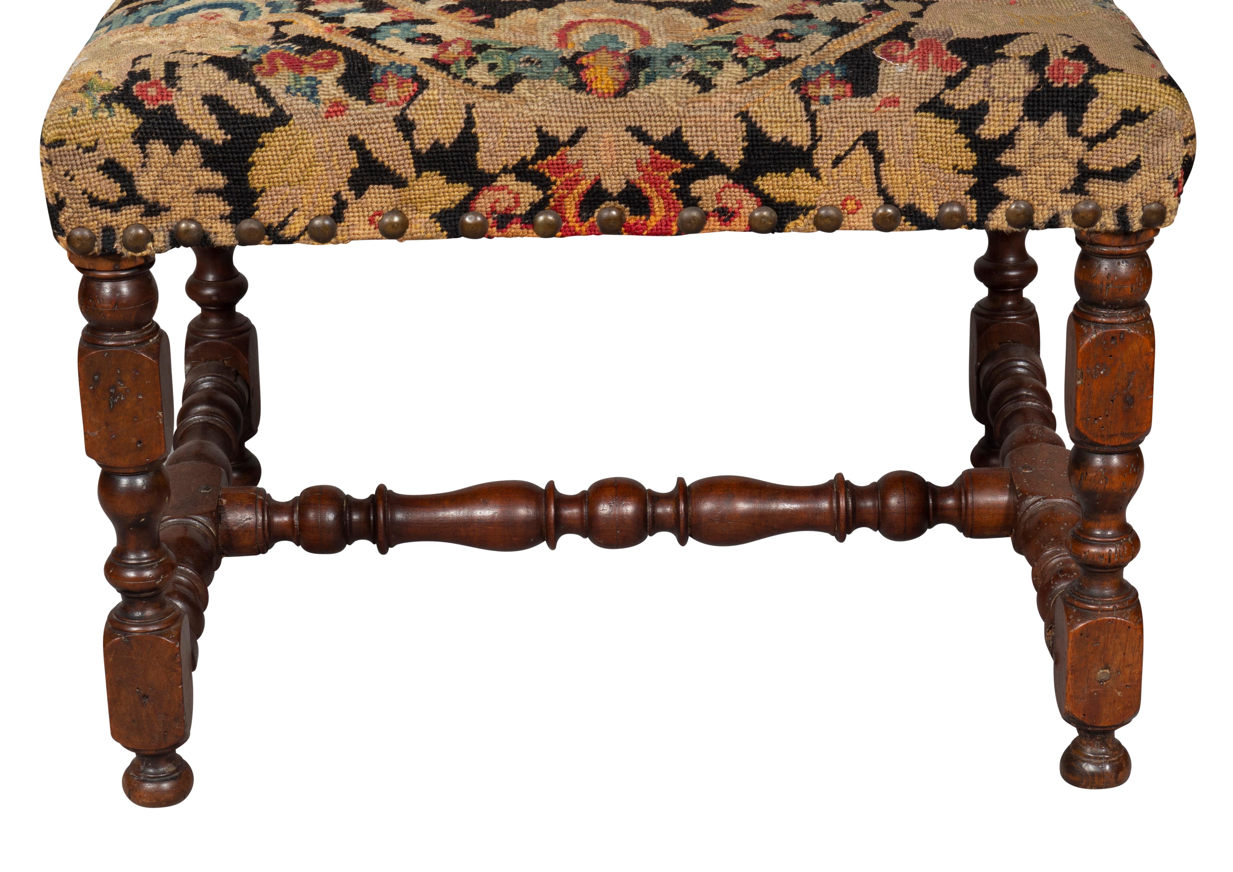 Rectangular with needlepoint seat raised on turned legs with H form turned stretcher.