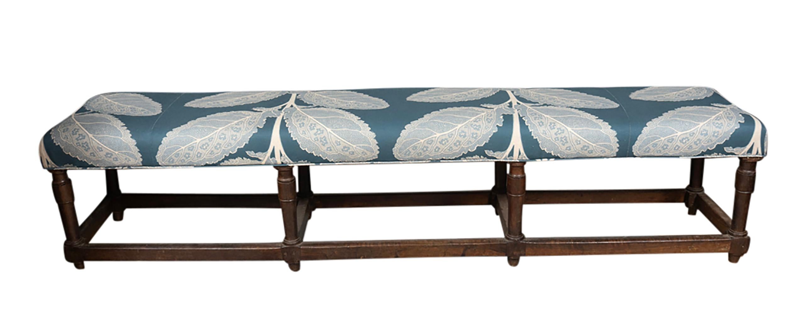 Unusual long size with upholstered seat and eight turned legs with box stretchers. Original old rich patina.