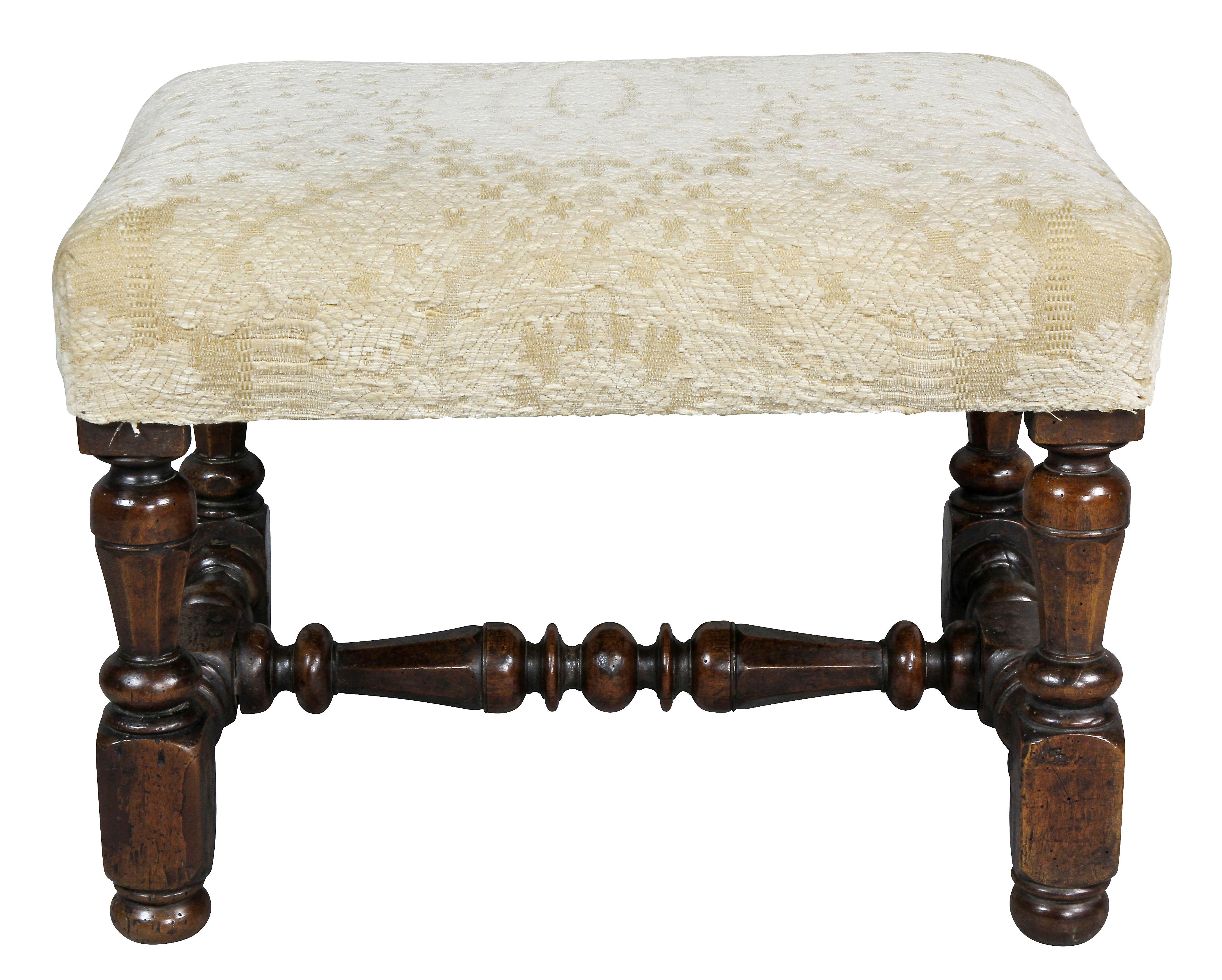Rectangular upholstered seat with turned legs joining an H form turned stretcher. Button feet.