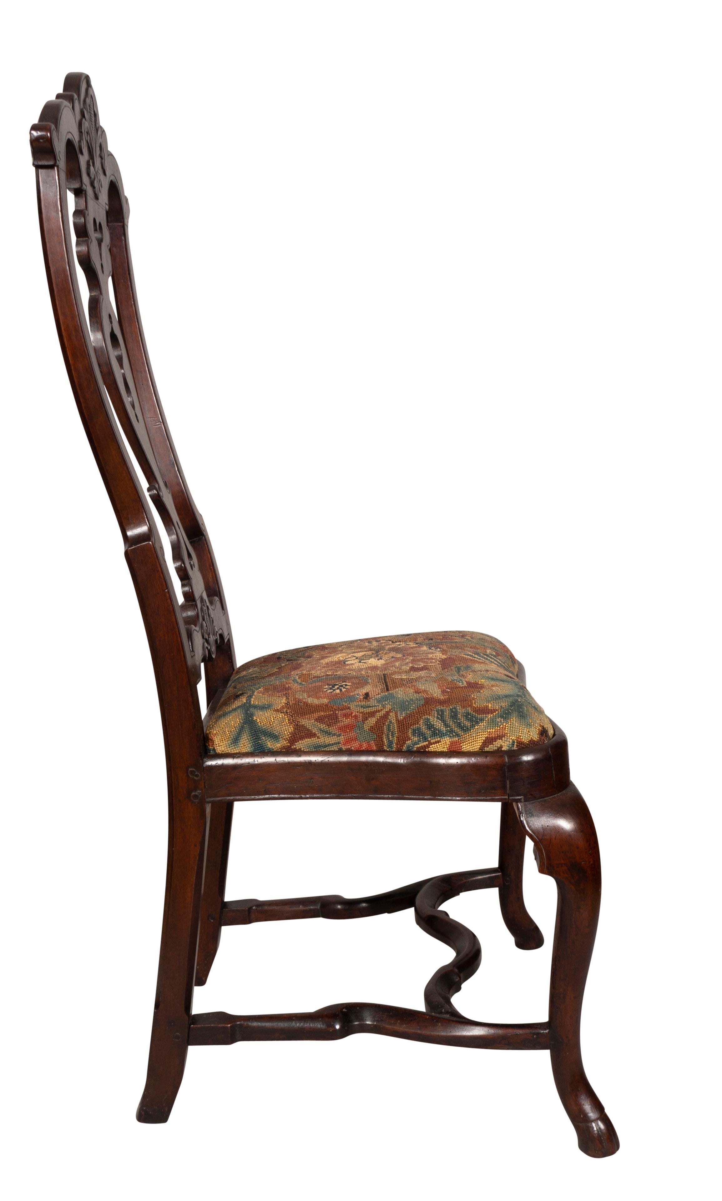 A wonderful whimsical chair with nicely carved details and needlepoint drop in seat. Cabriole legs and shaped H form stretchers.