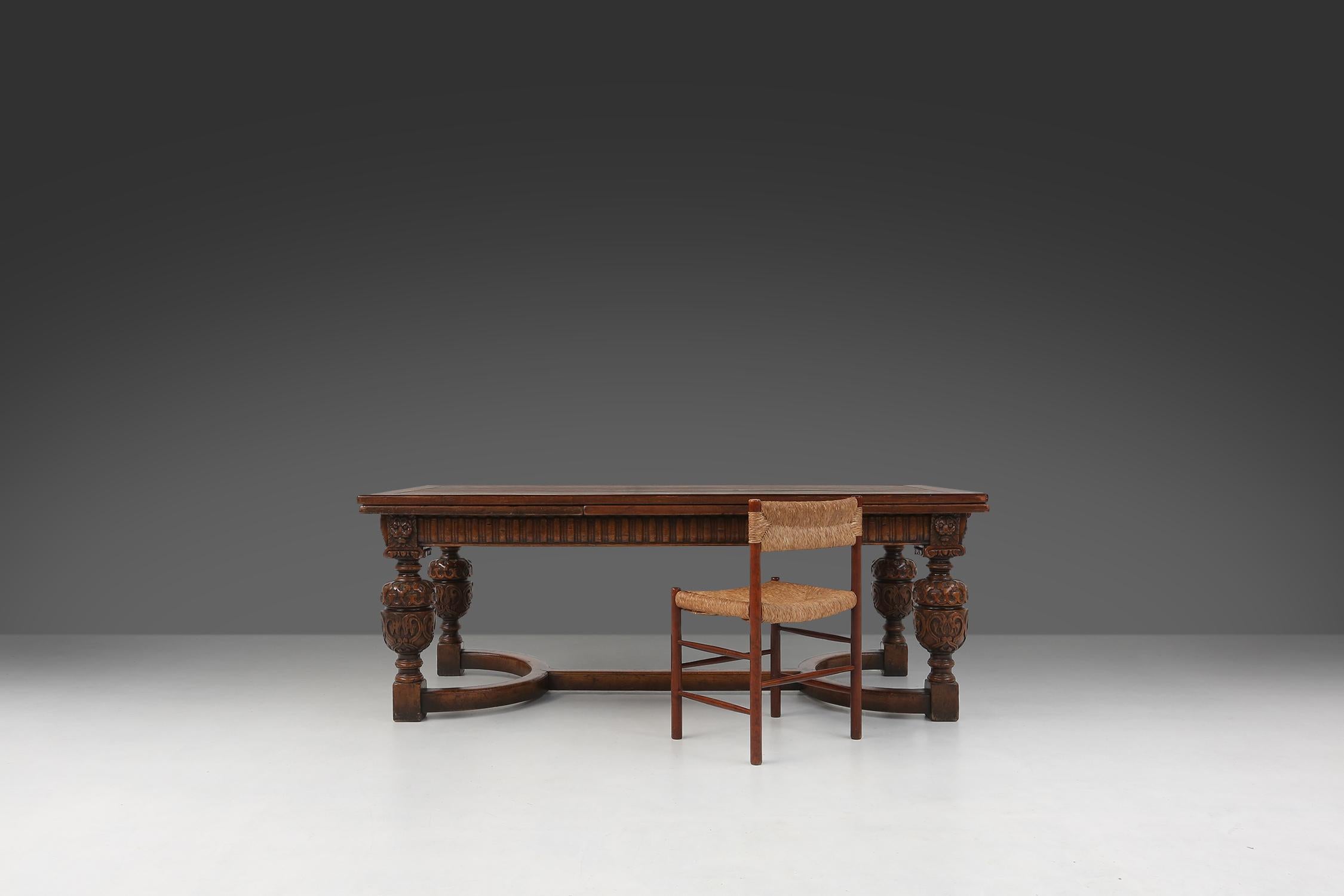 Flemish baroque 18th-century dining table in full oak. This beautiful table is decorated with lion heads and sculpted bulbous legs, testifying to the craftsmanship and style of Flemish cabinetmakers.

The four legs are connected by a crossbar, which