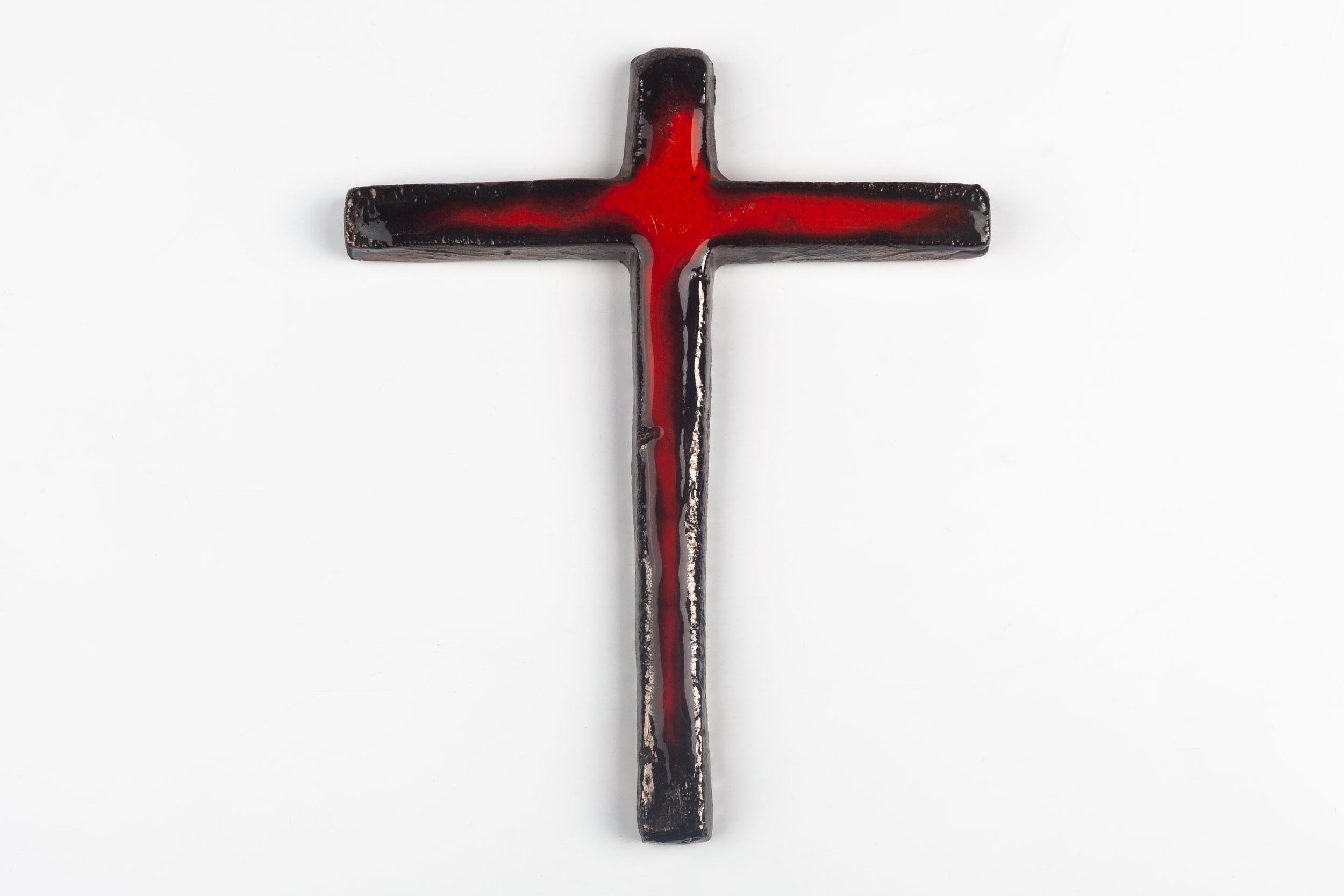 Midcentury European ceramic wall crucifix from a large collection of crosses handmade by Dutch artisans. High gloss glaze over red and black hand painted design.

From modernism to brutalism, the crosses in our collection range from being as