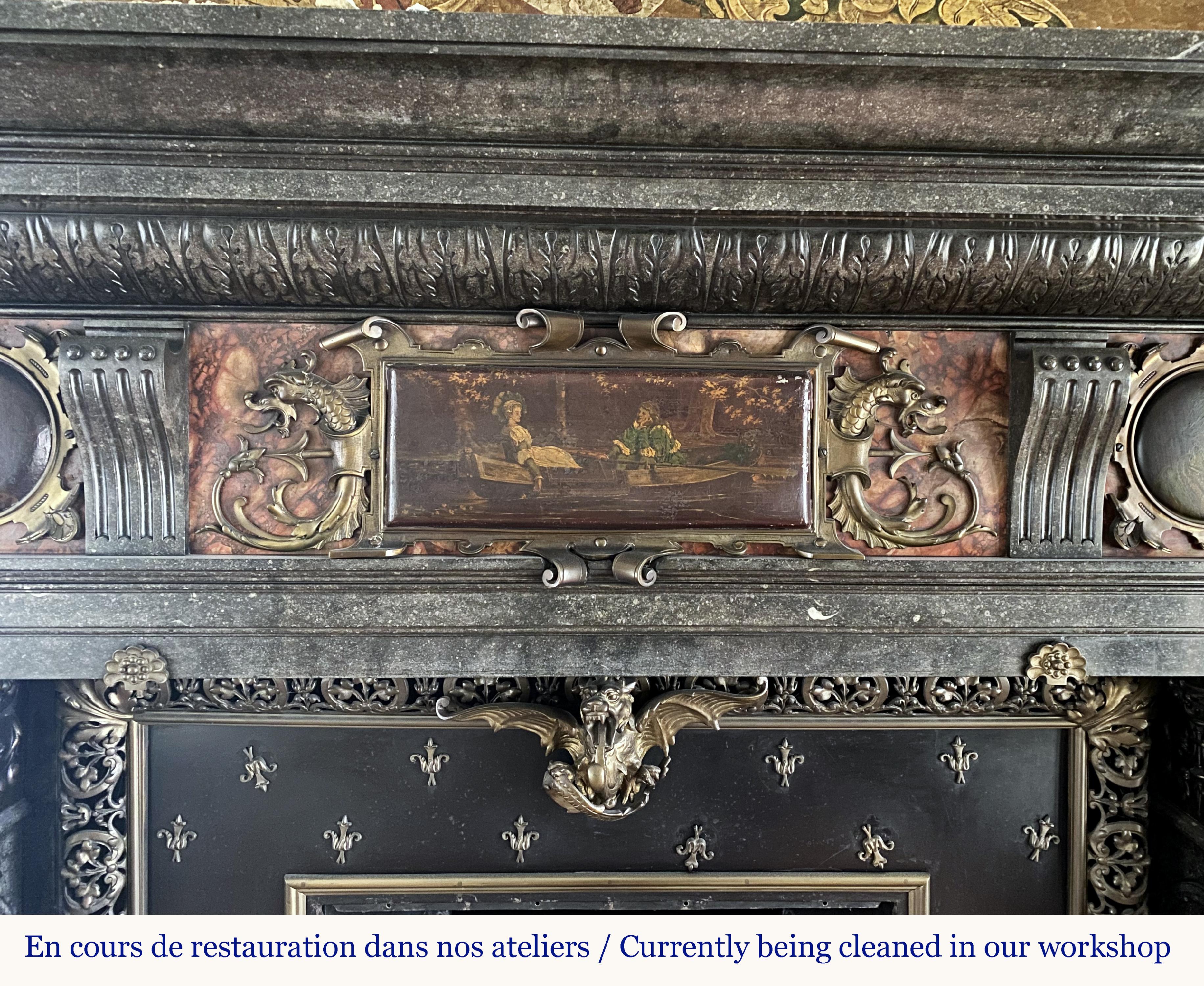 This monumental fireplace was made in Belgian Petit Granit in the second half of the 19th century inspired by the Flemish Renaissance art answering the revival vogue of this period.
Our fireplace shows a very rich sculpted decor and gilt bronze