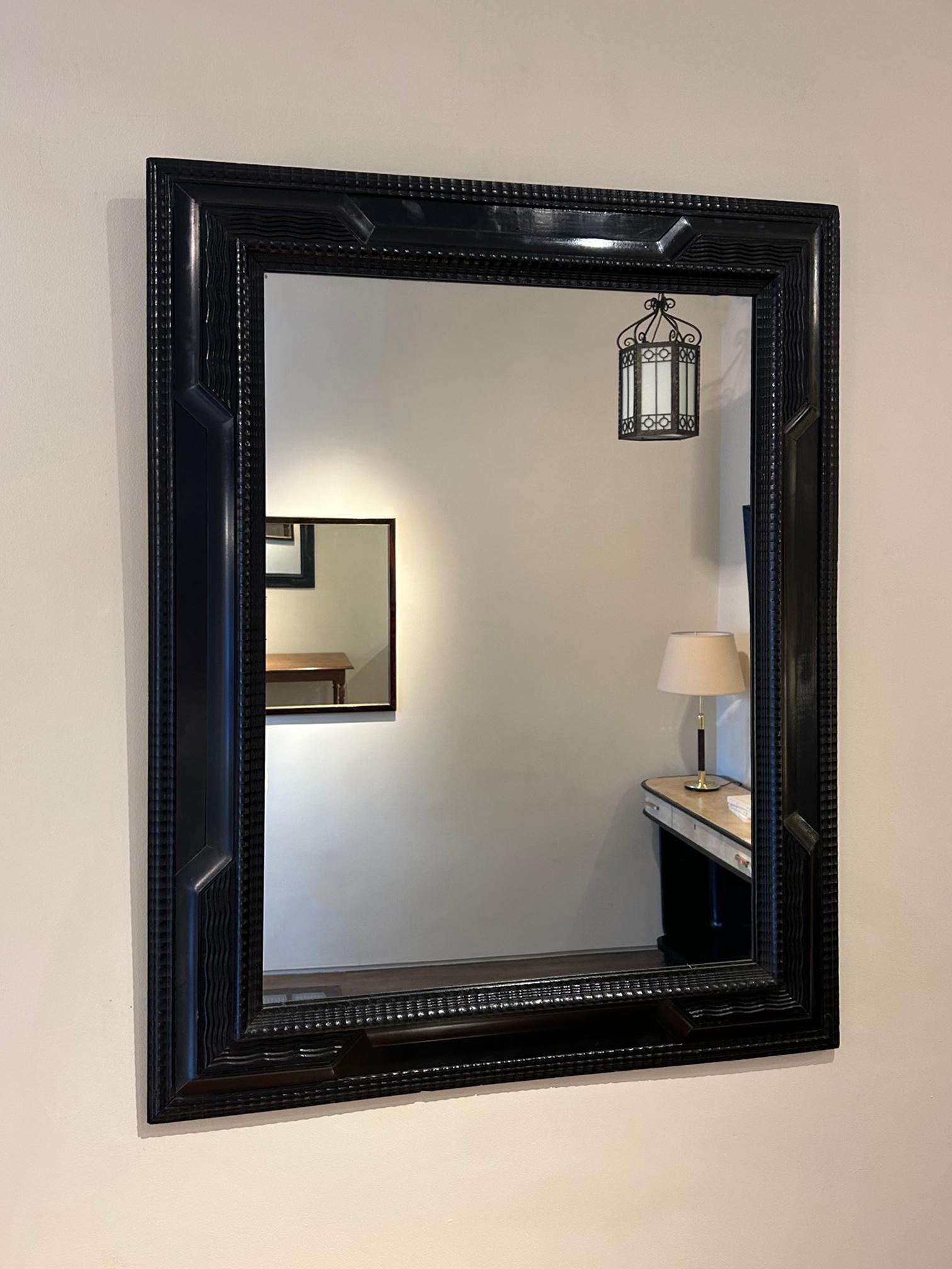 A Flemish style ebonised ripple frame mirror
Italy, mid 20th Century.
New mirror plate.
90.5 cm high by 70 cm wide by 4.5 cm depth