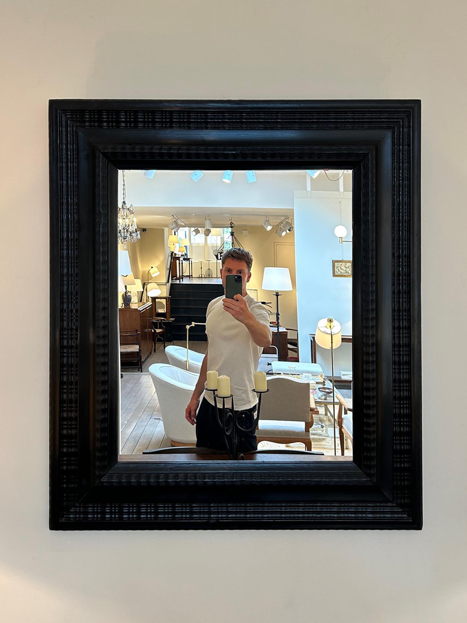 A Flemish style ebonised ripple frame mirror
Italy, mid 20th Century.
New mirror plate.
92 cm high by 81 cm wide by 6 cm depth