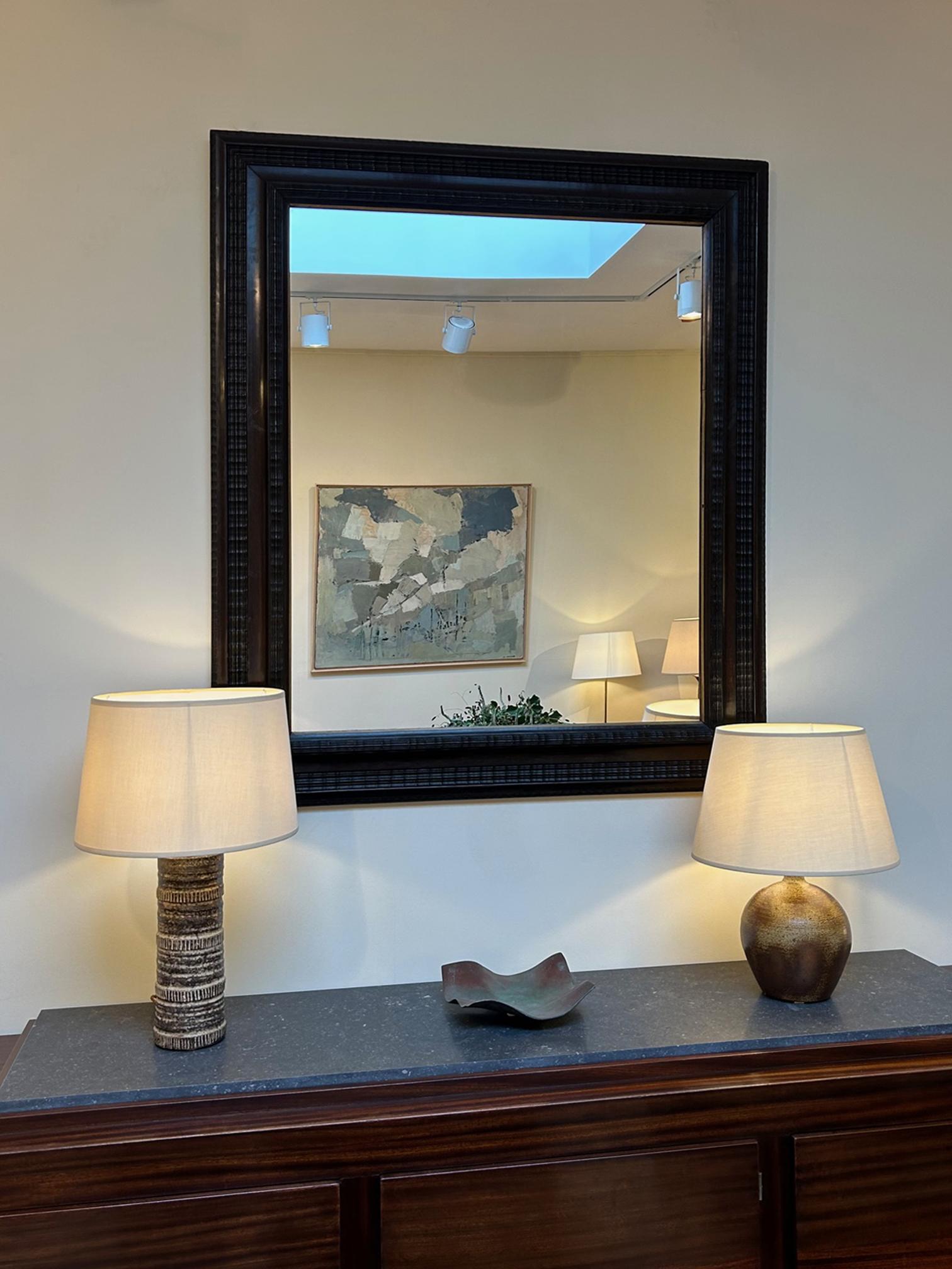 A Flemish style ebonised ripple frame mirror.
Continental, early 20th Century
127 cm high by 108.5 cm wide by 5.5 cm depth
