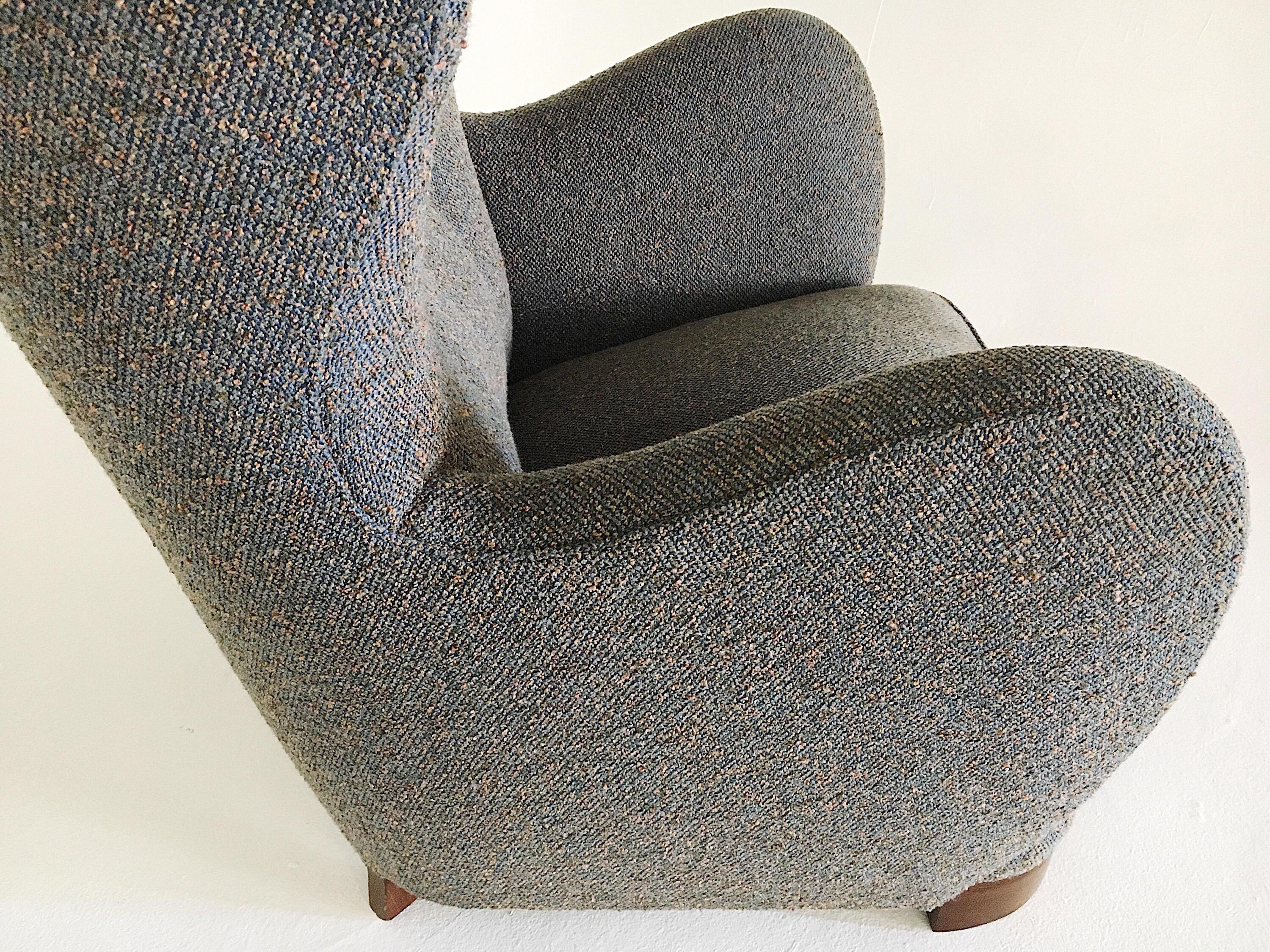 Danish lounge chair attributed to Flemming Lassen, circa 1940s. This is a fine and more unique example of the variants as it has a wool tweed-like boucle, often done in sheepskin/shearling. Standard is the stained beechwood legs and button tufting.