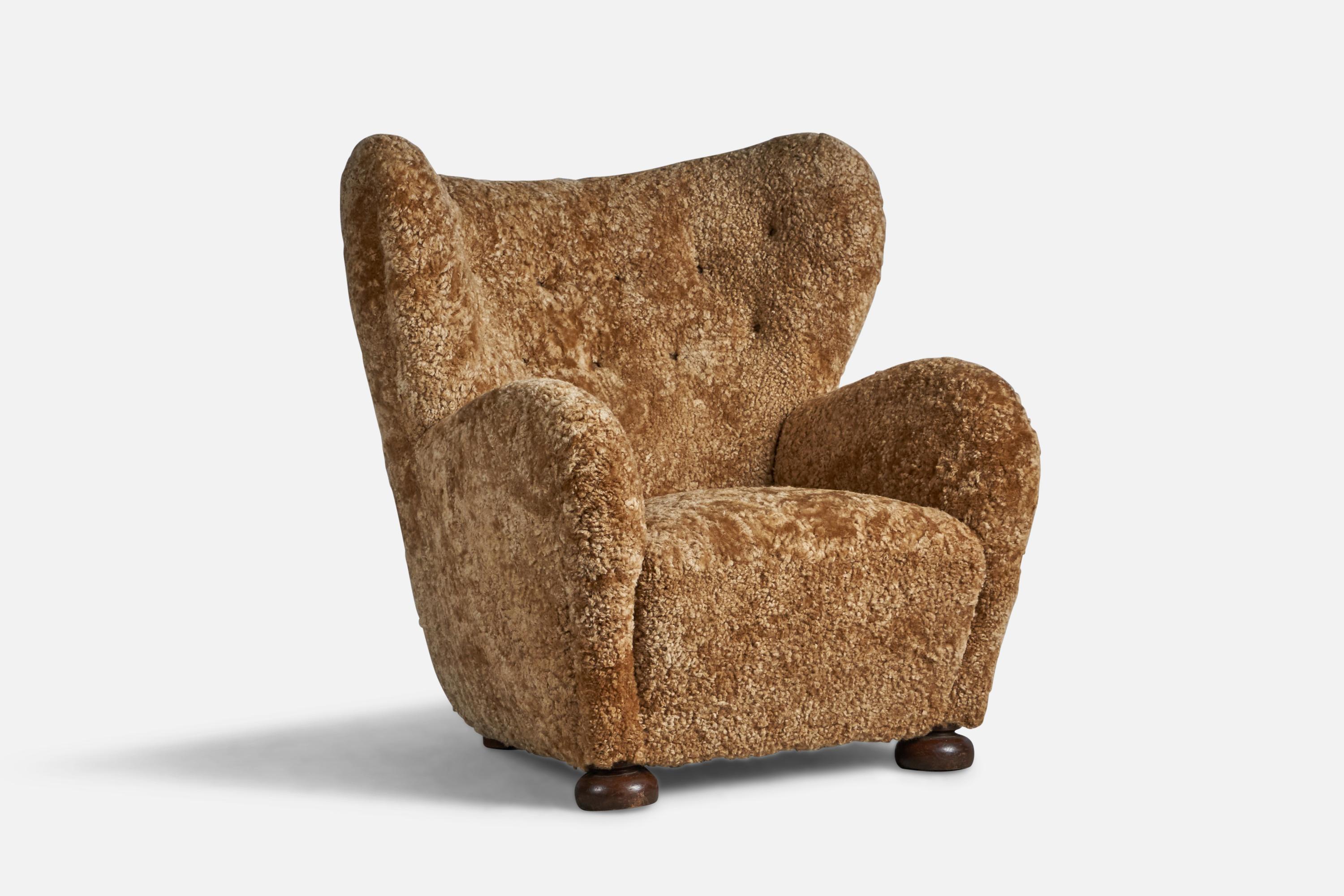 A sizeable stained wood and beige shearling lounge chair attributed to Flemming Lassen, Denmark, 1940s.

17.5