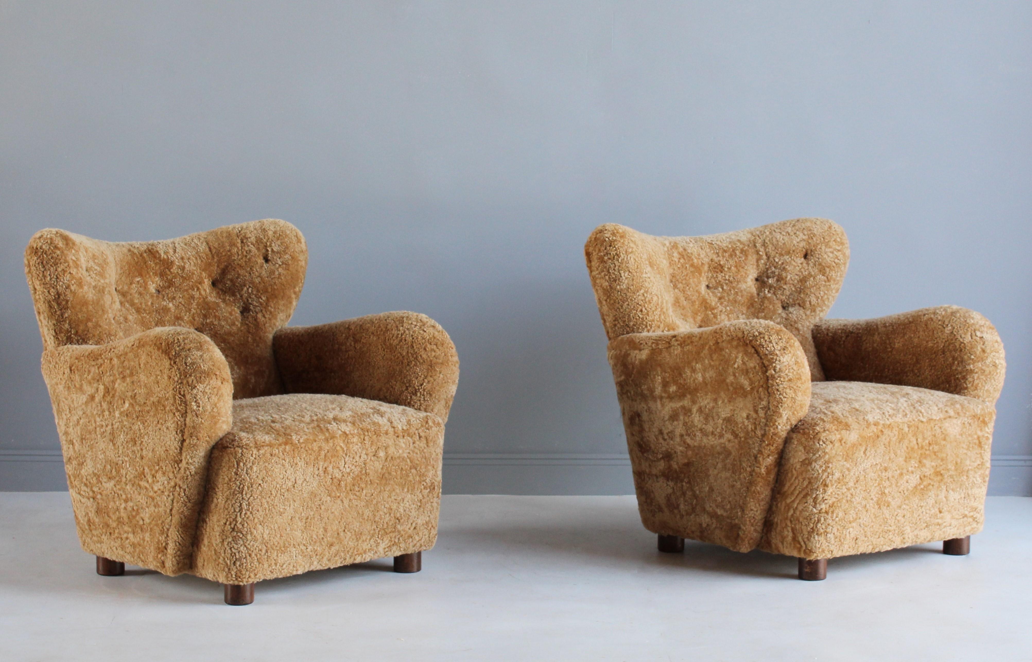 A pair of organic modernist 1940s lounge chairs attributed to Flemming Lassen. Produced in Denmark. Upholstered in authentic beige sheepskin / lambskin. Legs in dark stained beech. 

 Other designers of the period working in the organic style
