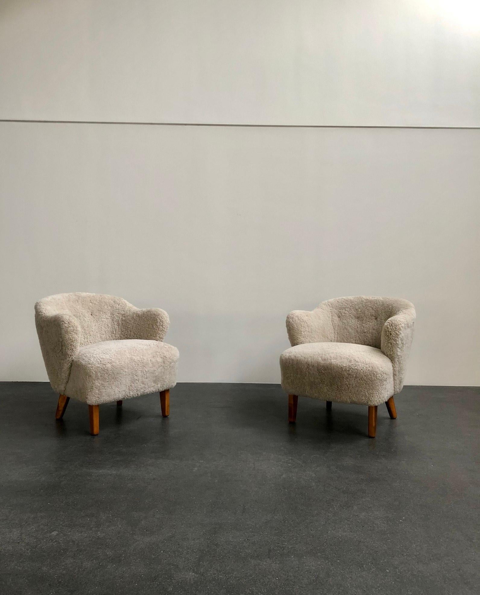 Flemming Lassen, pair of easy chairs for master cabinetmaker Jacob Kjaer, Denmark. Tapering legs in stained ash and reupholstered in beige sheepskin.

The model was presented at The Copenhagen Cabinetmakers' Guild Exhibition in 1940.

Price is for