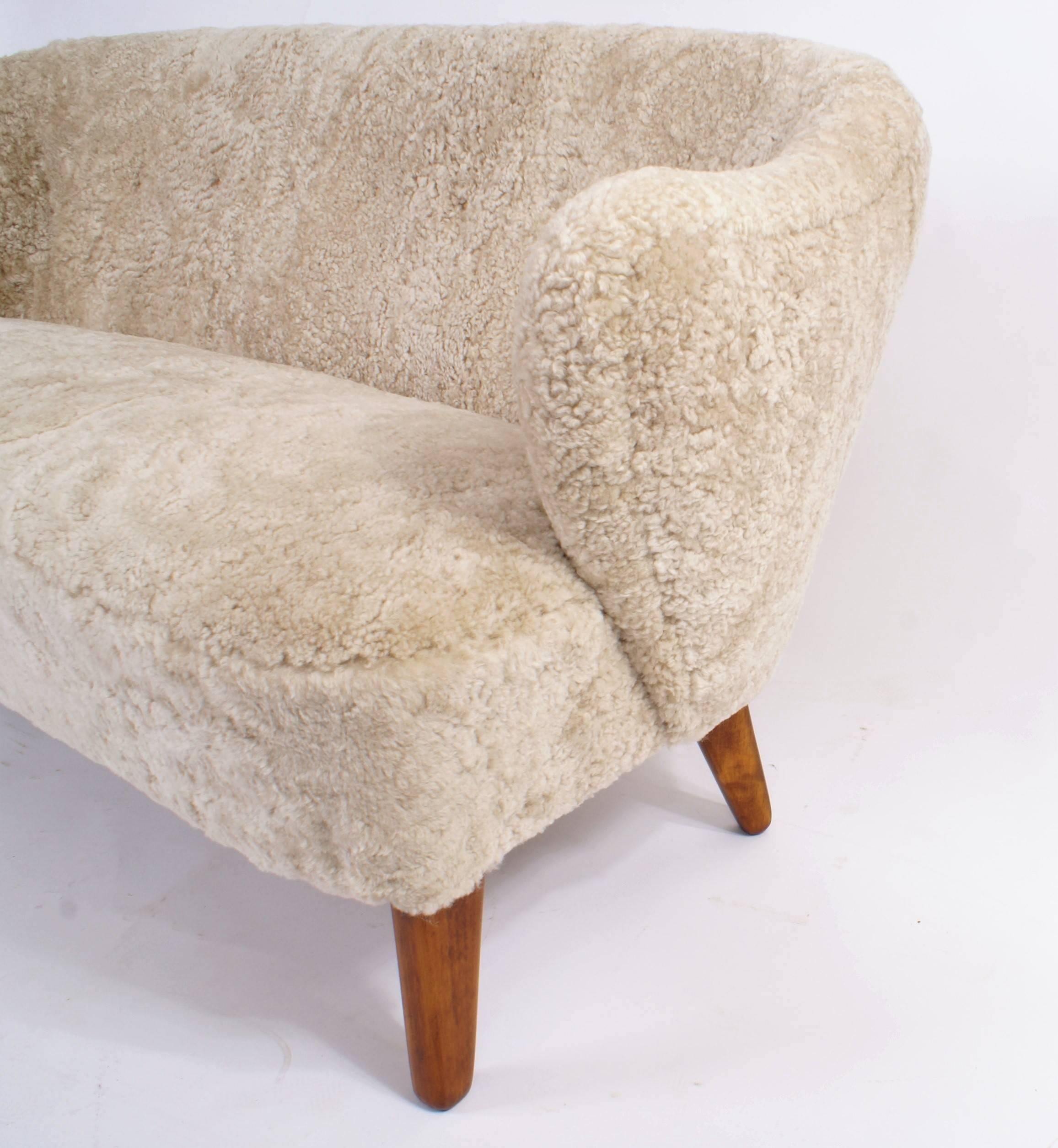 Flemming Lassen, two-seat settee for master cabinetmaker Jacob Kjær, Copenhagen. Beige sheepskin upholstery and ash legs. Designed 1940.

Please view 1stdibs item reference number LU1081215065911 for a pair of Flemming Lassen easy chairs that match
