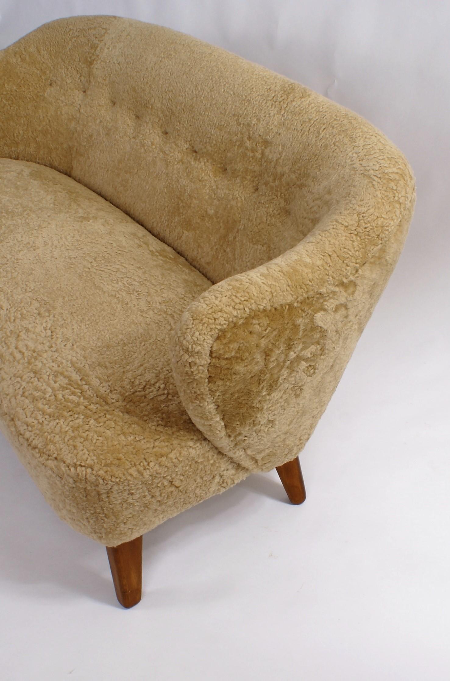Flemming Lassen, two-seat settee for master cabinetmaker Jacob Kjær, Copenhagen. Natural/honey colored sheepskin upholstery, leather buttons and stained ash legs. Designed 1940.

Please view 1stdibs item reference number LU1081213317962 for pair of