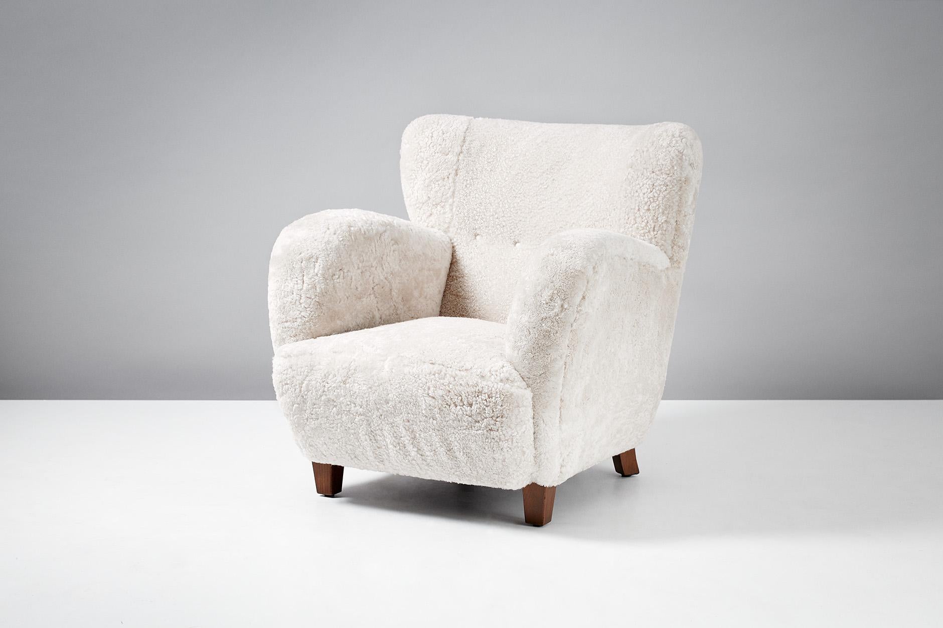 Danish cabinetmaker made lounge chair, circa 1930s.

Large lounge chair produced in Denmark in the 1930s in the manner of Flemming Lassen. Stained beech legs and recently reupholstered in New Zealand sheepskin.
 