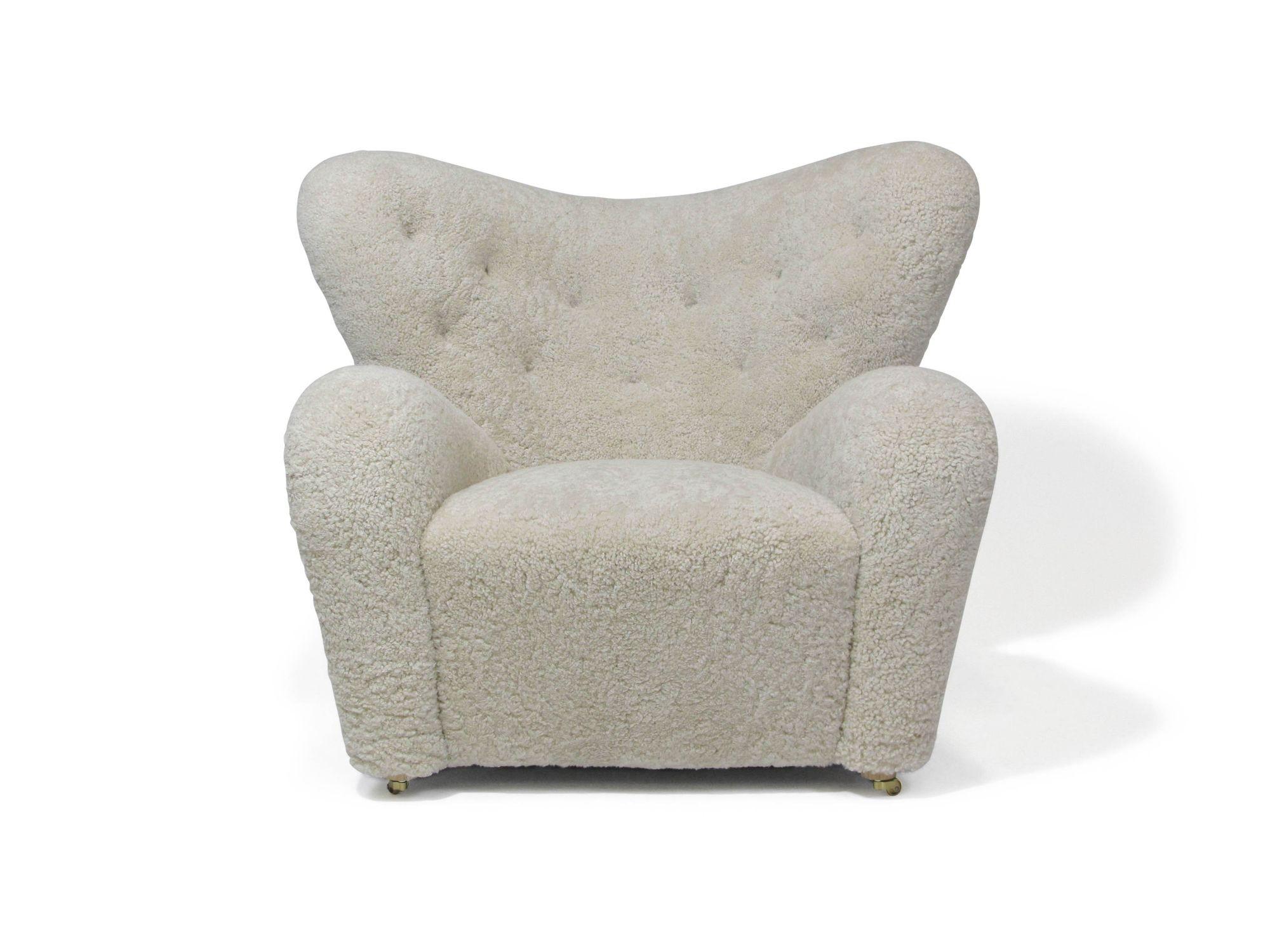 Tired Man lounge chair and ottoman designed by Flemming Lassen for the Copenhagen Cabinetmakers Guild Exhibition of 1935. This large, sculpted form lounge chair is a danish modern classic, fully upholstered in natural shearling with button tufted