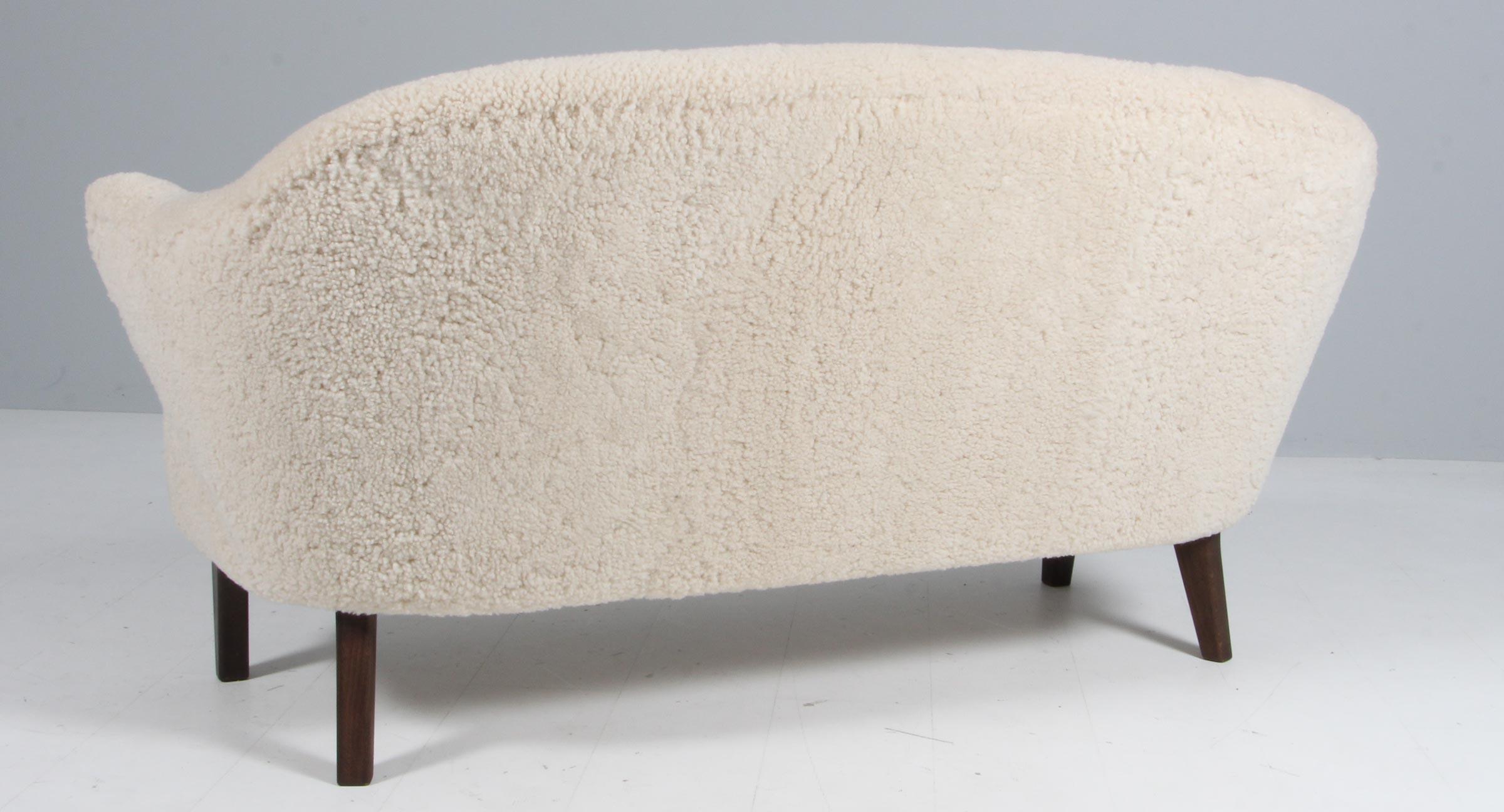 Flemming Lassen Zweisitzer-Sofa, original gepolstert mit Lammfell.

Beine aus geräucherter Eiche.

Modell Ingeborg, hergestellt von Audo.