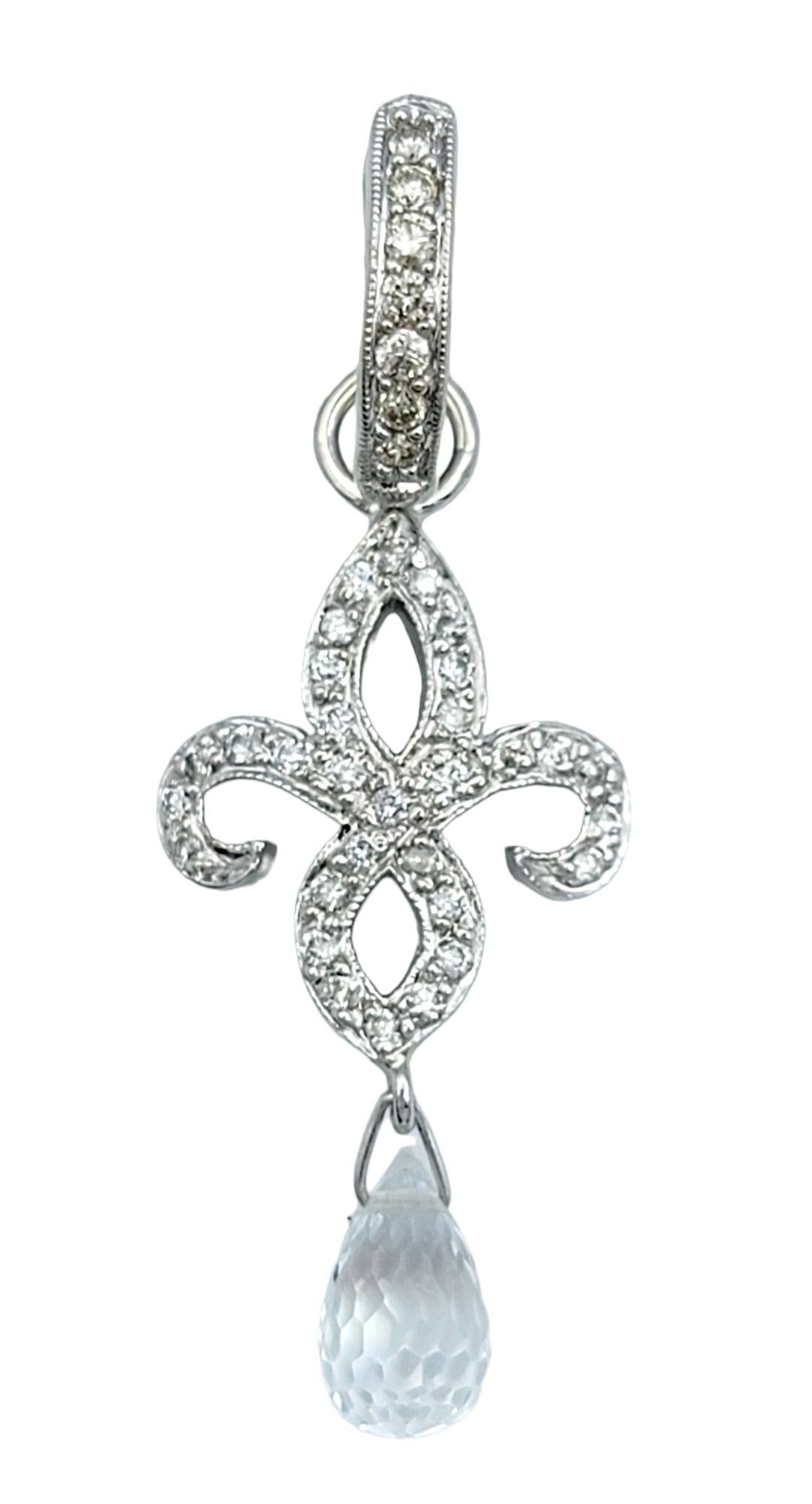 Introducing a mesmerizing pair of diamond fleur de lis dangle earrings with briolette cut topaz charms. They are a stunning blend of elegance and sophistication, masterfully crafted in 18 karat white gold. These earrings feature the iconic fleur de