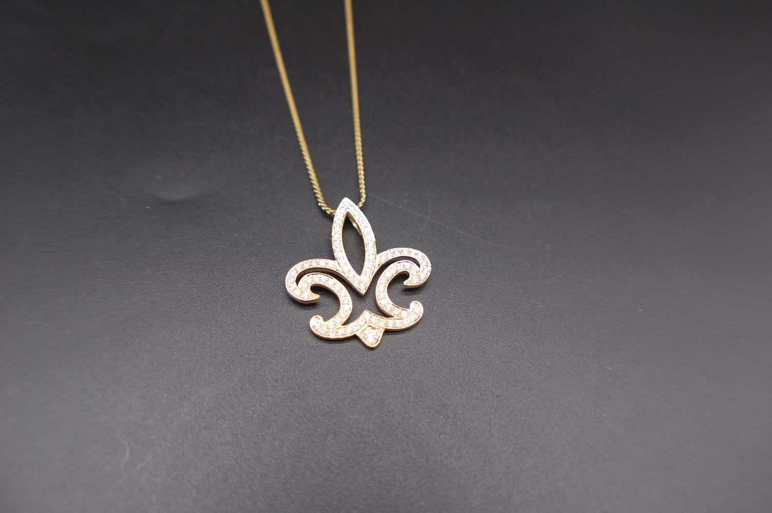 Schöner Fleur De Lis Anhänger und Kette bestehend aus pflastergeschliffenen Diamanten. Der Anhänger misst 1 Zoll im Durchmesser und hat einen schweren, doppelten Bügel für Ketten bis zu 5,5 mm Breite.
Der obere Teil des Anhängers ist mit Diamanten