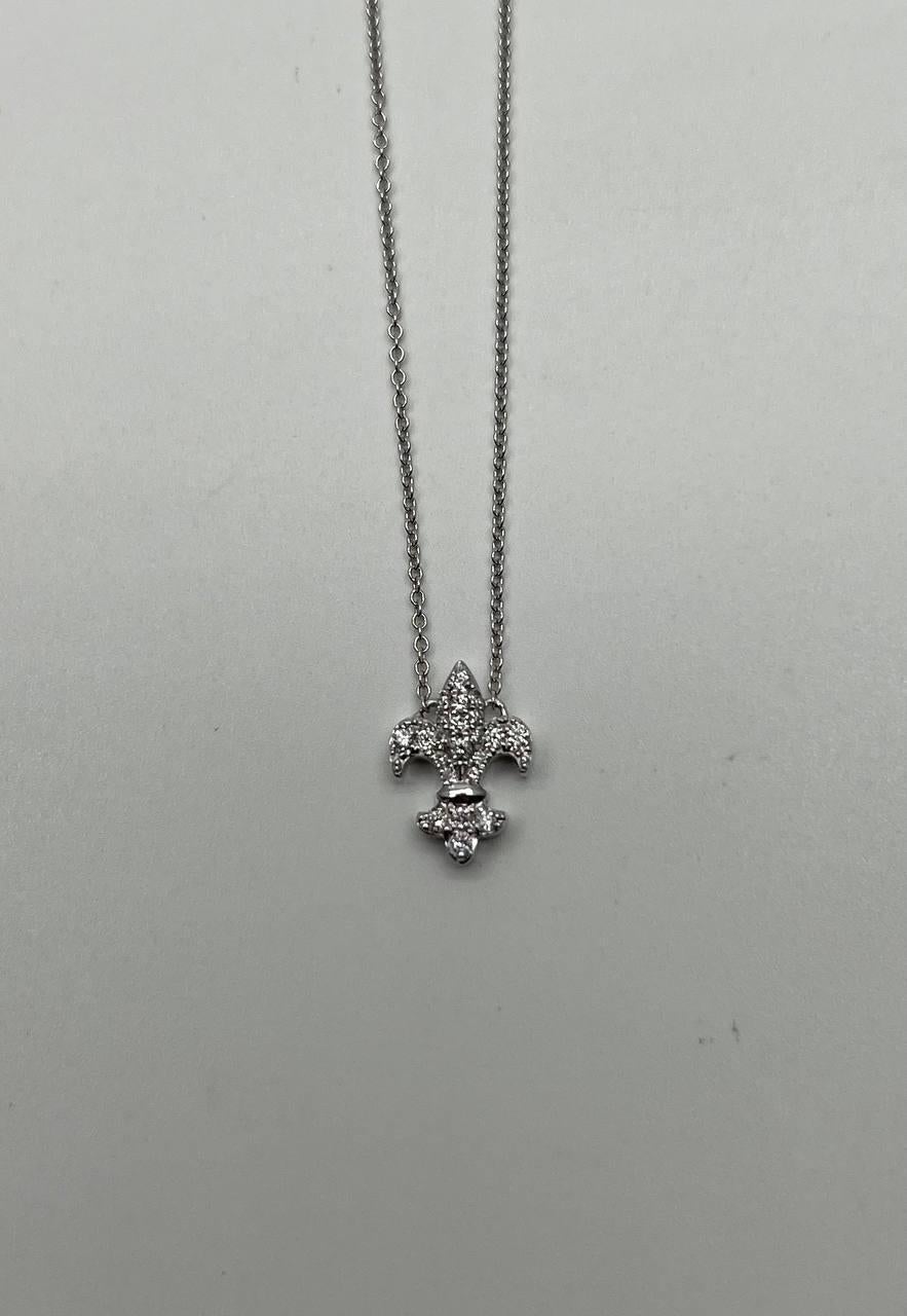 This exquisite necklace is crafted in 18k white gold. The pendant features a delicate fleur-de-lis design adorned with sparkling white diamonds. The diamonds are meticulously set, enhancing the intricate details of the pendant. 
Metal: 18k White