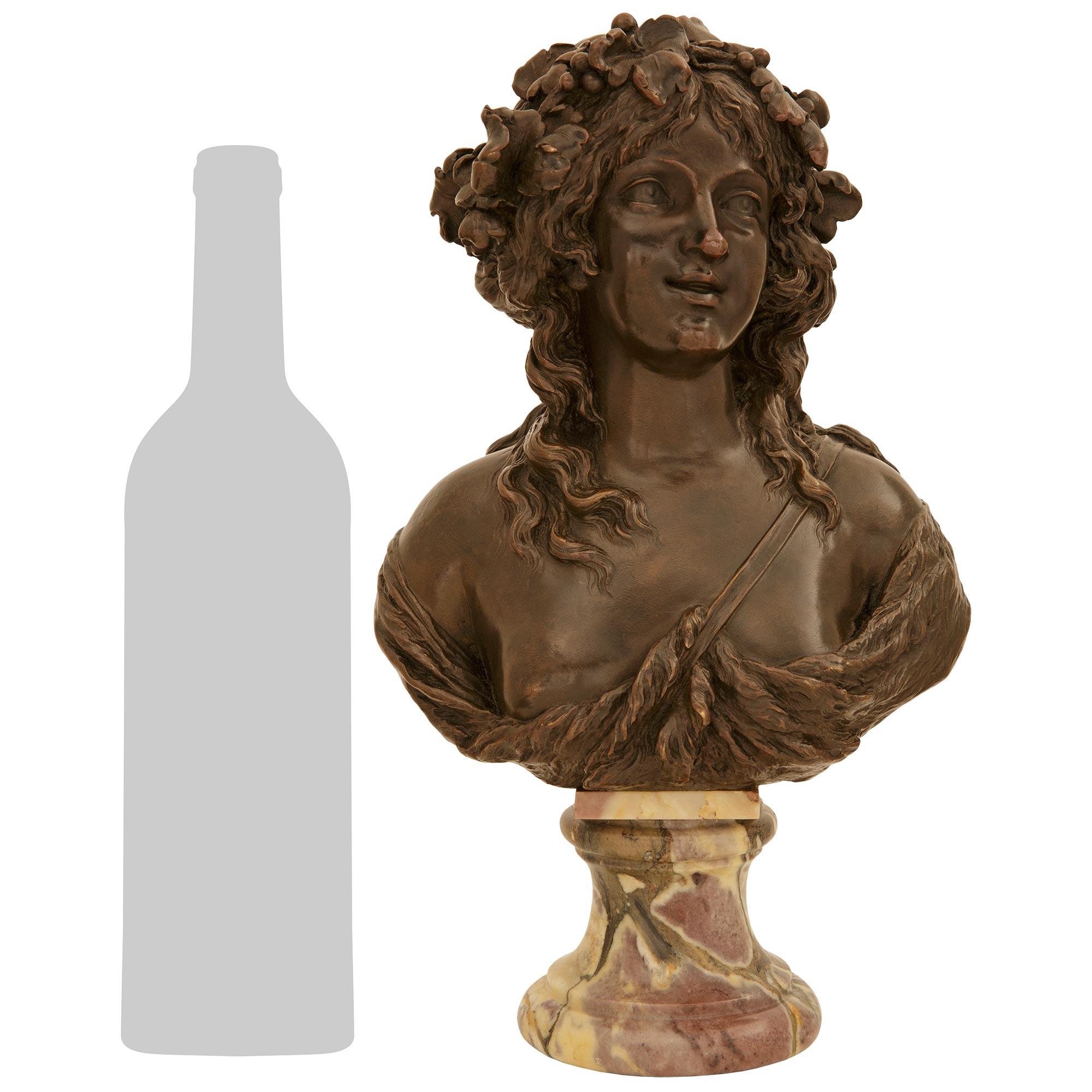 A charming and most elegant French early 19th century patinated Bronze and Fleur de Pêcher marble bust of a young Baccante, signed Marin, 1794. The wonderful bust is raised by a circular mottled Fleur de Pêcher marble socle. Above is the wonderfully