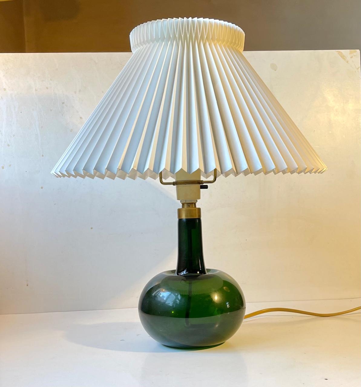 Handblown deep green glass table lamp designed by Michael Bang and manufactured by Holmegaard in Denmark during the late 1970. It is called Fleur. Label from Holmegaard still present beneath the base. Height with shade holder: 38 cm.The shade holder