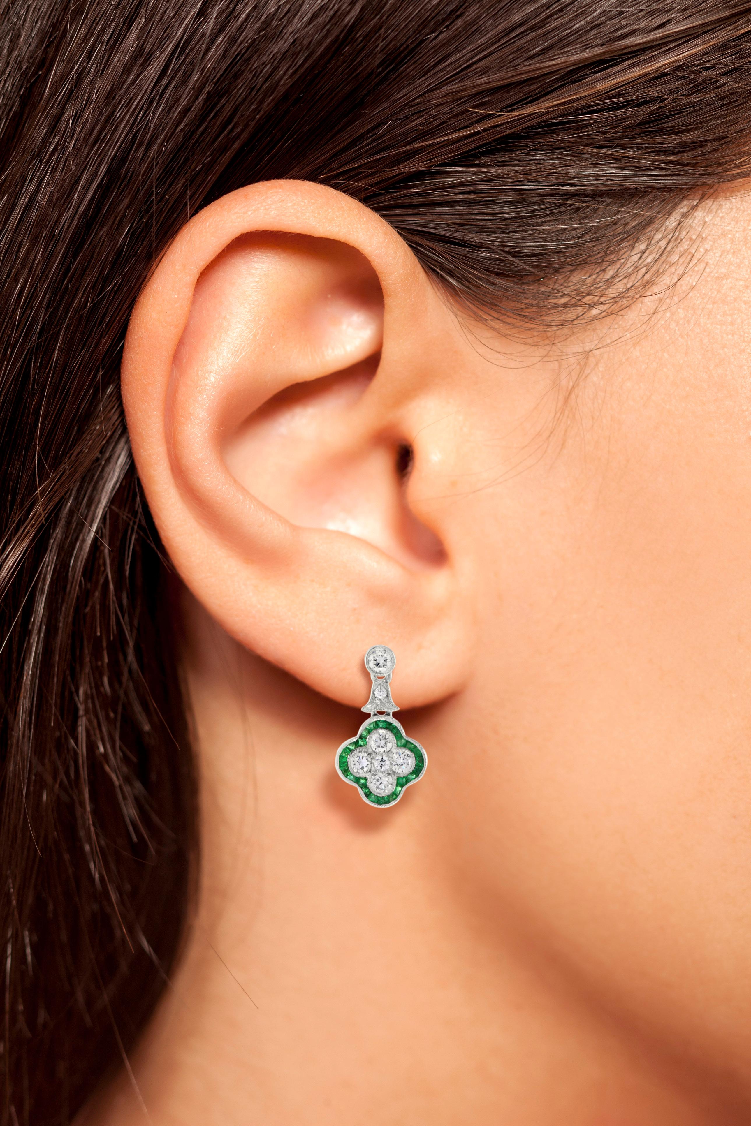 A lovely pair of earrings for anyone who loves antique-inspired jewelry. Made of dazzling round cut diamond and French cut emerald set on 18k white gold. Total fourteen diamonds form a flower with an emerald trim design for a beautifully feminine