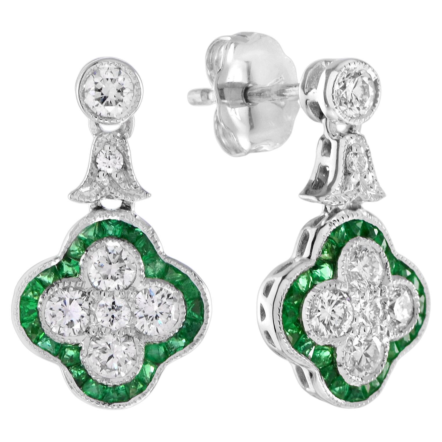 Boucles d'oreilles pendantes en or blanc 18 carats, composées d'une grappe de trèfles en diamants ronds et émeraudes.