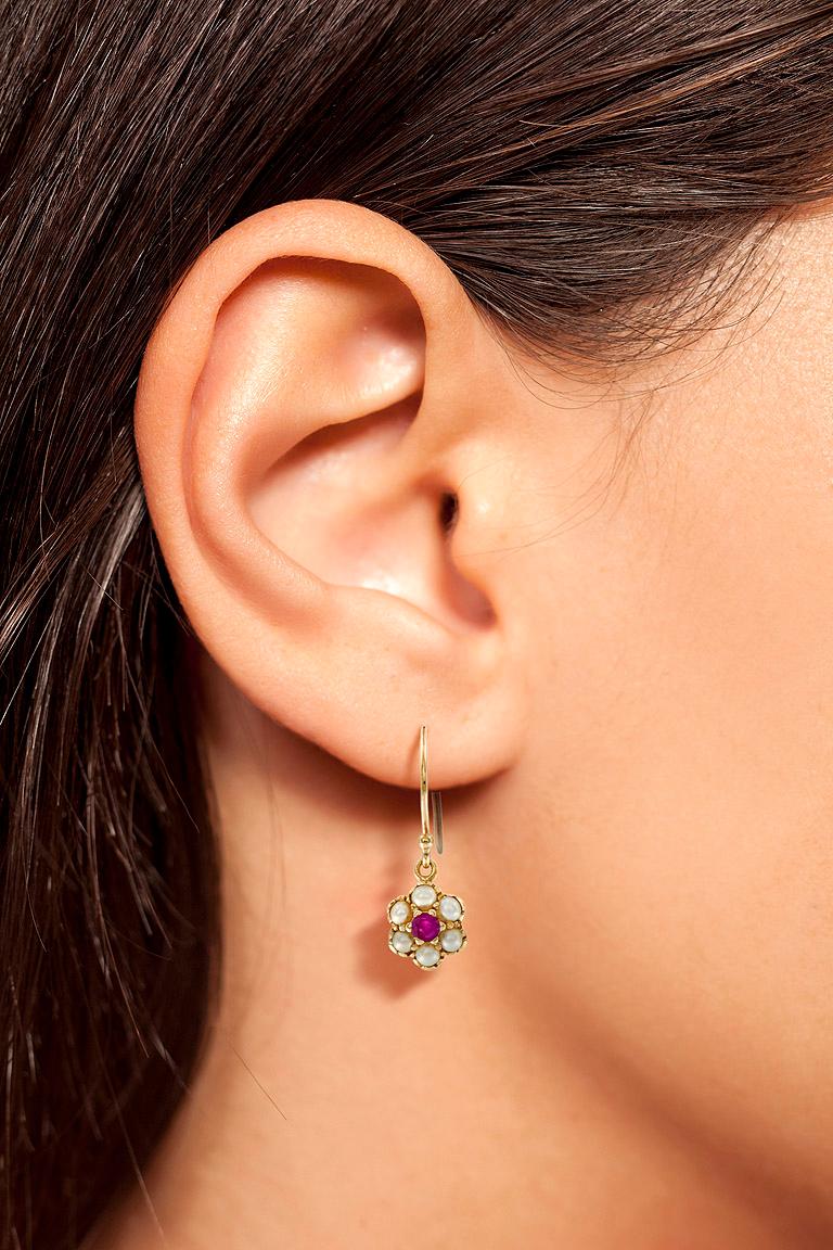 Bring a touch of a lovely floral design to your wardrobe with this pair of ruby and diamond drop earrings arranged in the shape of an antique bloom.

Information
Metal: 14K Yellow Gold
Width: 8 mm.
Length: 22 mm.
Weight: 2.10 g. (approx. total