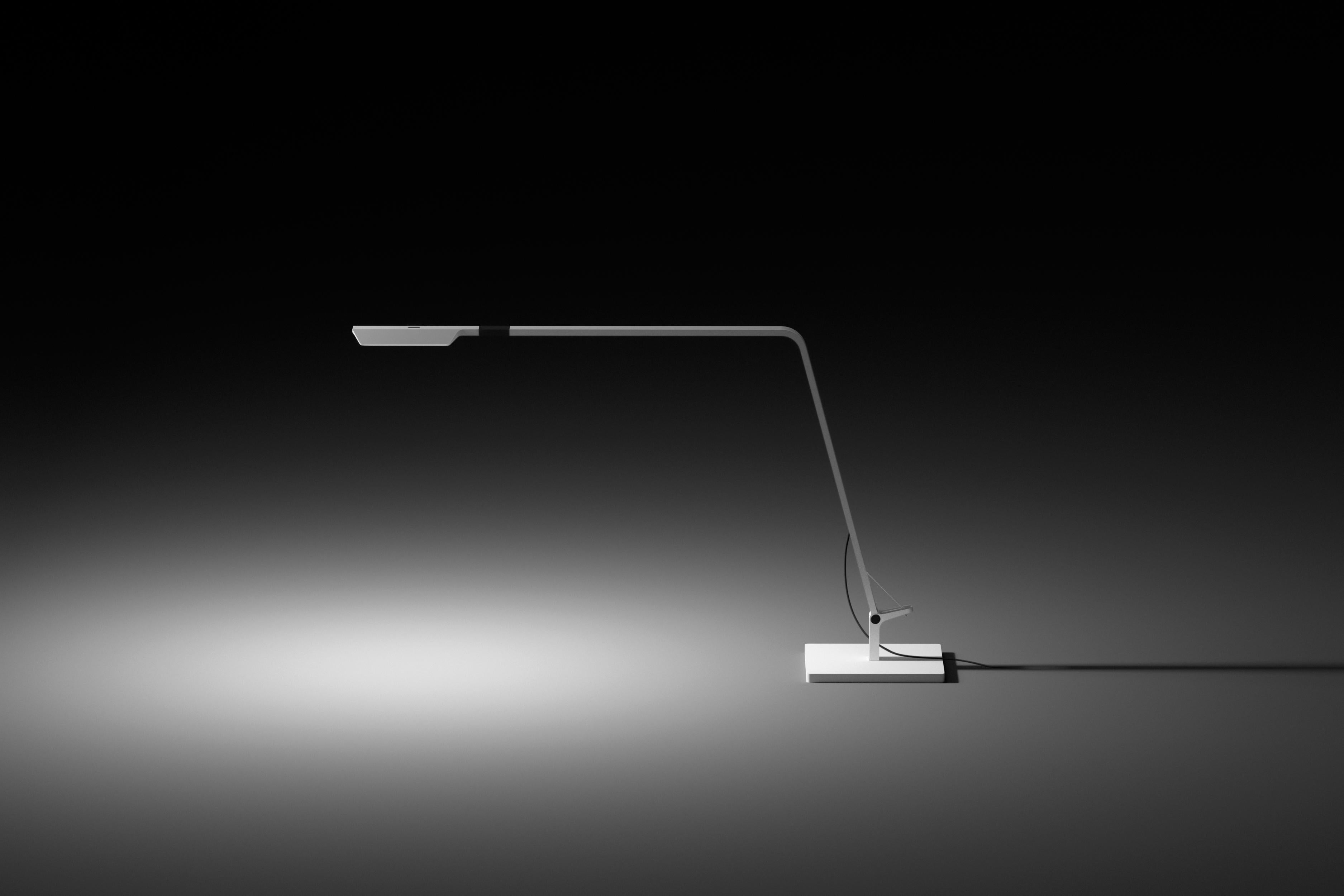 Subtle beauty for contemporary work spaces. Flex is a fully adjustable task-driven table lamp. Its sleek, low profile design, and flexible head make it the perfect balance of form and function. Designed by Ramos & Bassols. Available in a white or