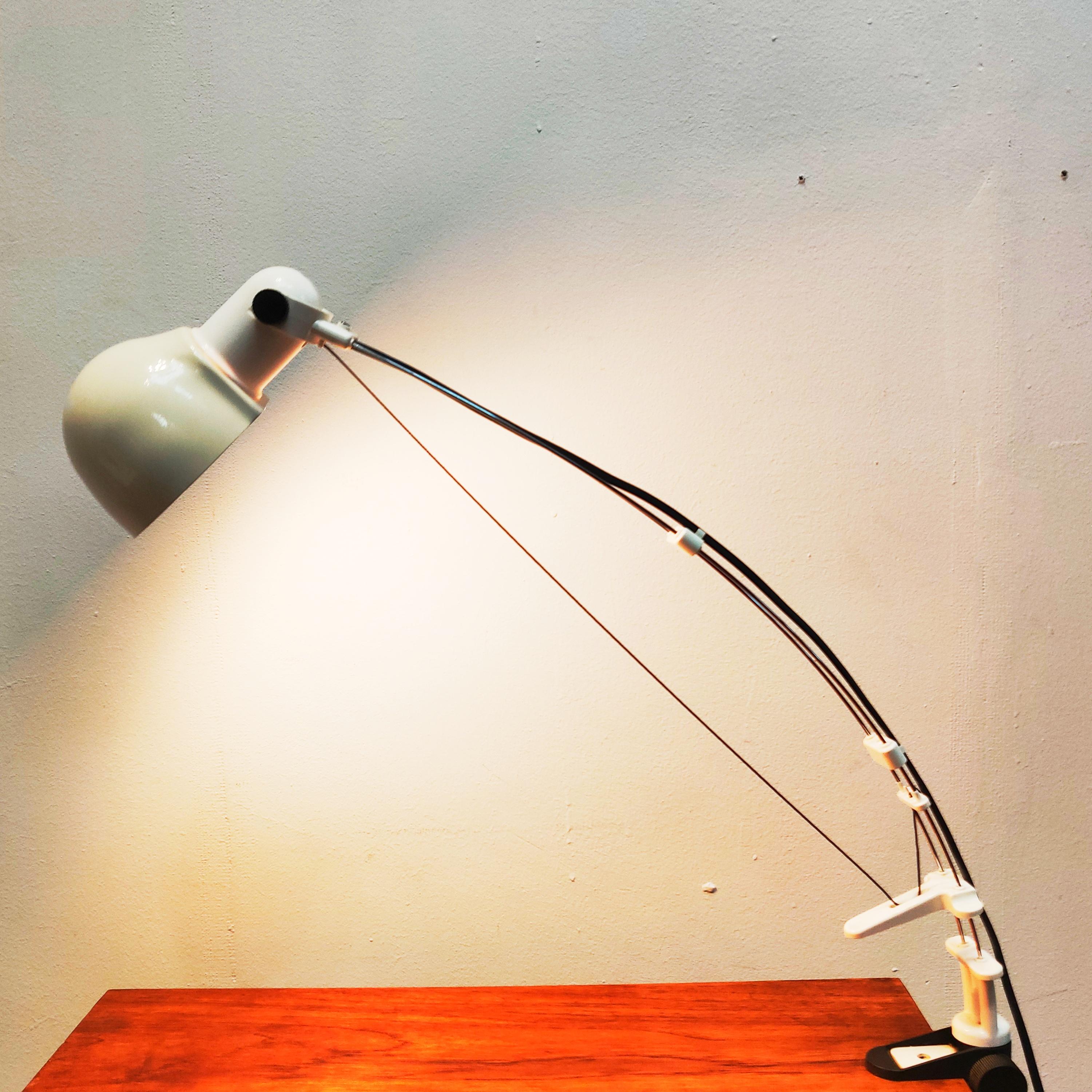 Flex Wire desk clamp lamp, 1970s.
Characteristic sculptural desk lamp which is adjustable in height by pulling or stretching the wire, the shade is adjustable and the lamp can rotate. The lamp has a clamp mounting to clamp it on the table or