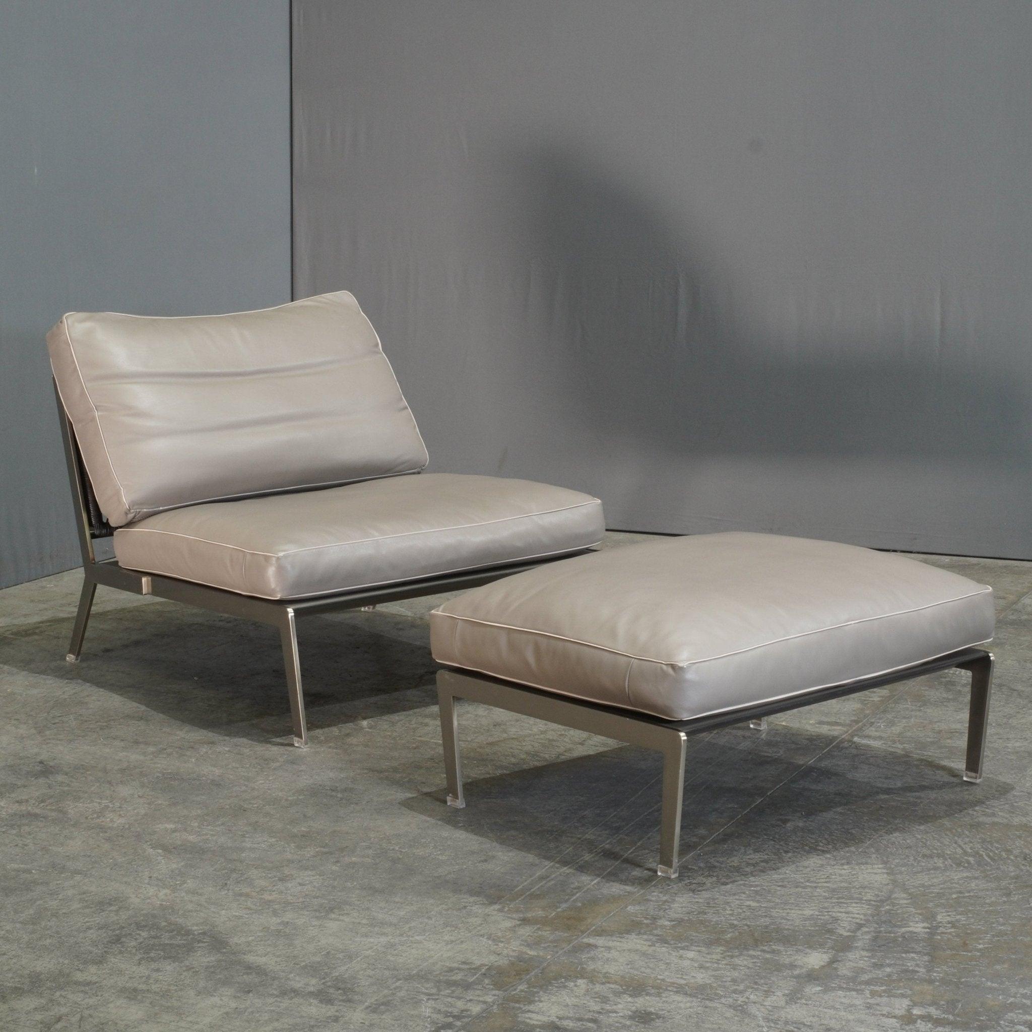 Le fauteuil et le pouf Flexform Happy d'Antonio Citterio incarnent l'élégance contemporaine avec une touche minimaliste. Fabriqué avec un cadre métallique tubulaire élégant, le fauteuil est doté d'un rembourrage luxueux qui vous enveloppe dans le