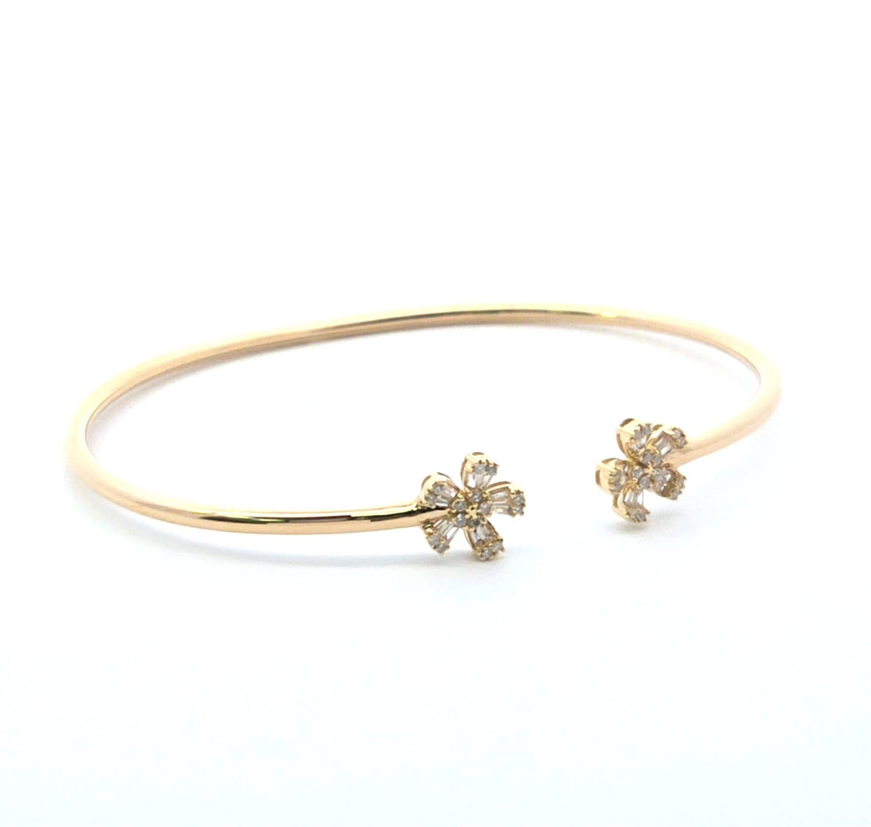 Schlichter Luxus mit unserem flexiblen Blumenarmreif aus Gelbgold mit Diamanten - ein wunderschön gearbeiteter offener Armreif, der sich sanft um das Handgelenk legt. Jedes Ende ist mit einer zart geformten Blume aus Diamanten im Baguette- und