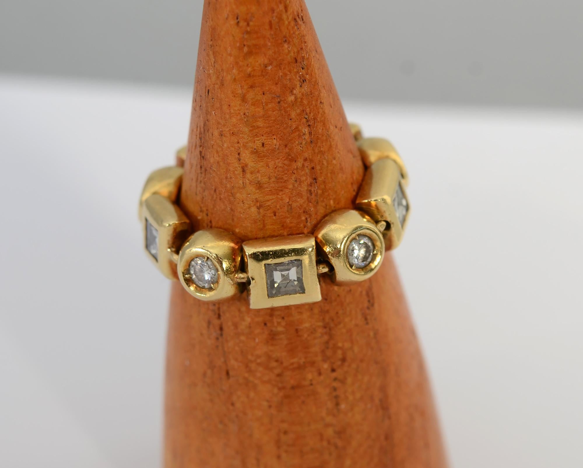 Eighteen karat gold band ring with alternating round and square diamonds. The ten stones weigh a total of approximately 1 carat. The alternating jeweled links are joined with oval connectors making the ring totally flexible. It is size 6. The ring