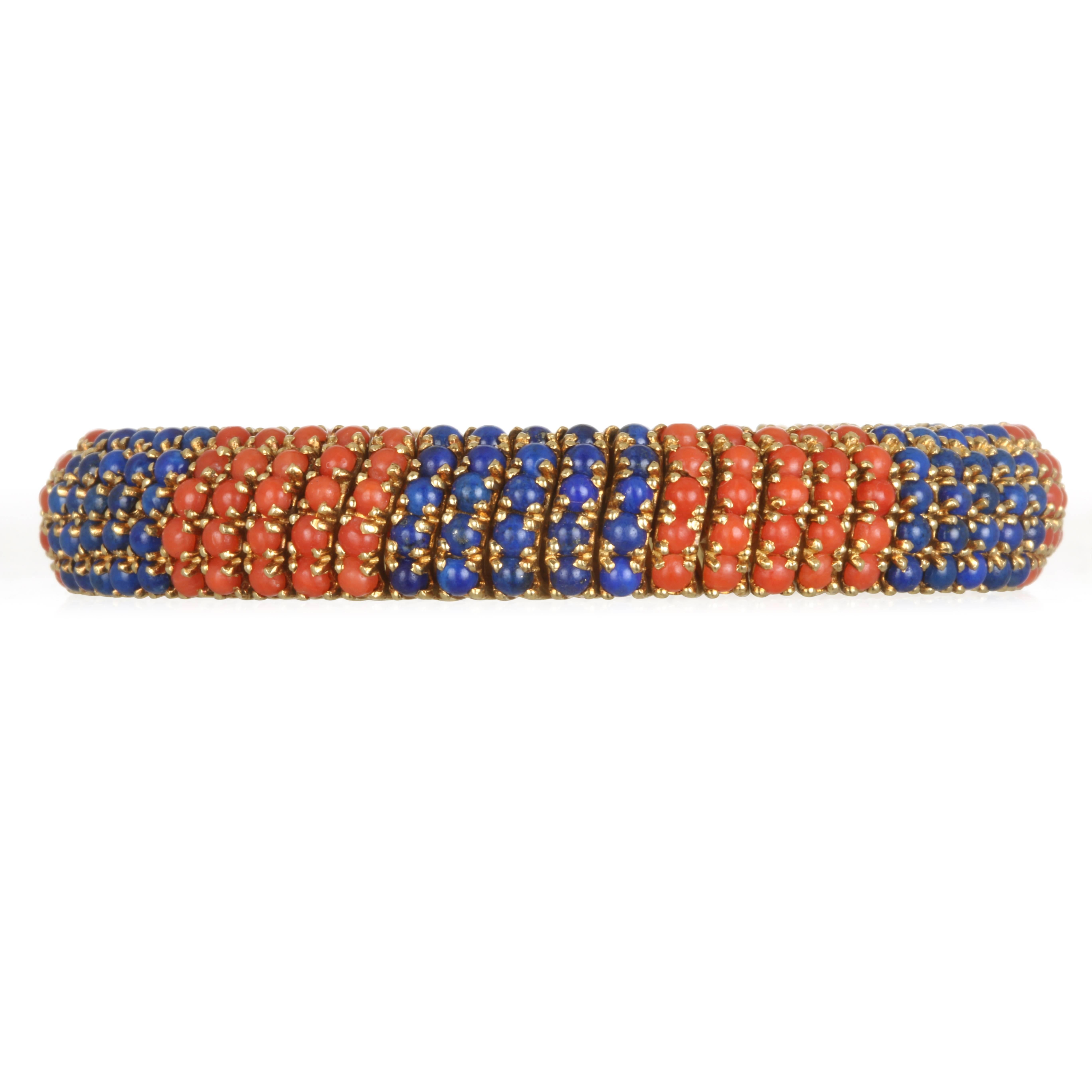 Skillfully crafted in 18k yellow gold, this unique bracelet is slightly domed and beautifully finished inside and out. Vibrant blue Lapis and deep Coral beads are classic, timeless and beautifully complement one another.  
Length 7.5