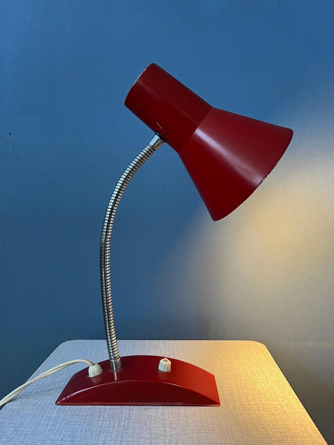 Lampe de table rouge de l'ère spatiale avec bras métallique flexible. Le bras et l'abat-jour peuvent être positionnés de la manière souhaitée. La lampe est en métal. La lampe nécessite une ampoule E27/26 (standard) et dispose actuellement d'une
