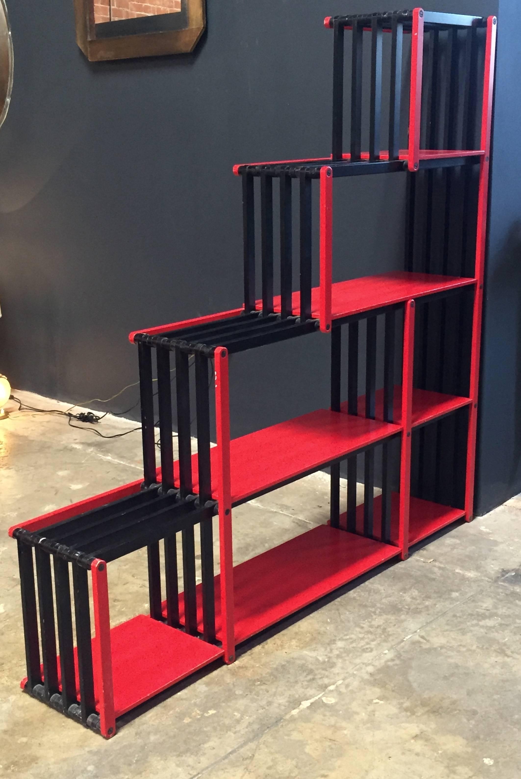 Flexible wood bookcase, Italy, 1980s
Structure lacquered in black and shelves in red.
It bends whatever you want it to hold your books, objects and treasures.