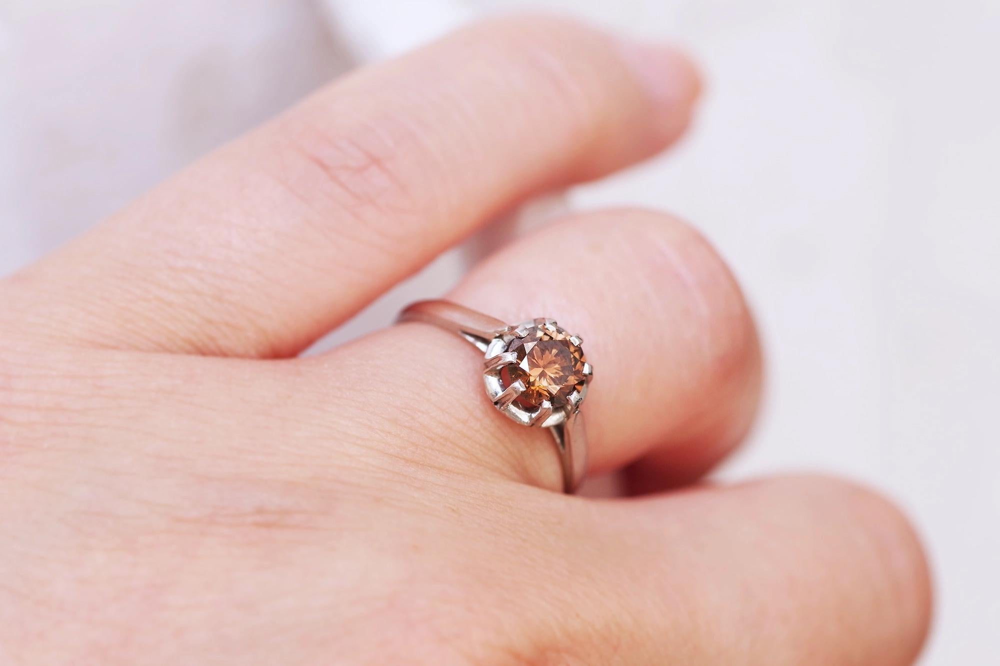 Fancy brown diamond ring. Fancy brown diamond ring: a solitaire diamond fancy cognac ring in platinum. This ring is centered on a magnificent brilliant cut fancy diamond, whose brown color sparkles with orange. The diamond weighs 0.79 carat and is