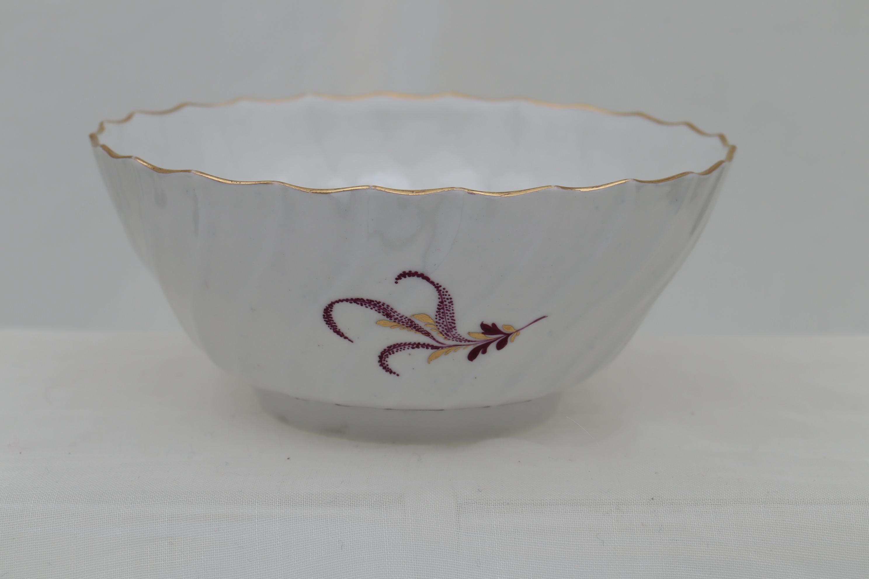 This fluted porcelain slop bowl by Flight and Barr, Worcester is decorated with hand painted flower sprigs done in puce and gold. There are three such sprigs on the outside and one on the bottom of the inside, together with an undulating puce ring